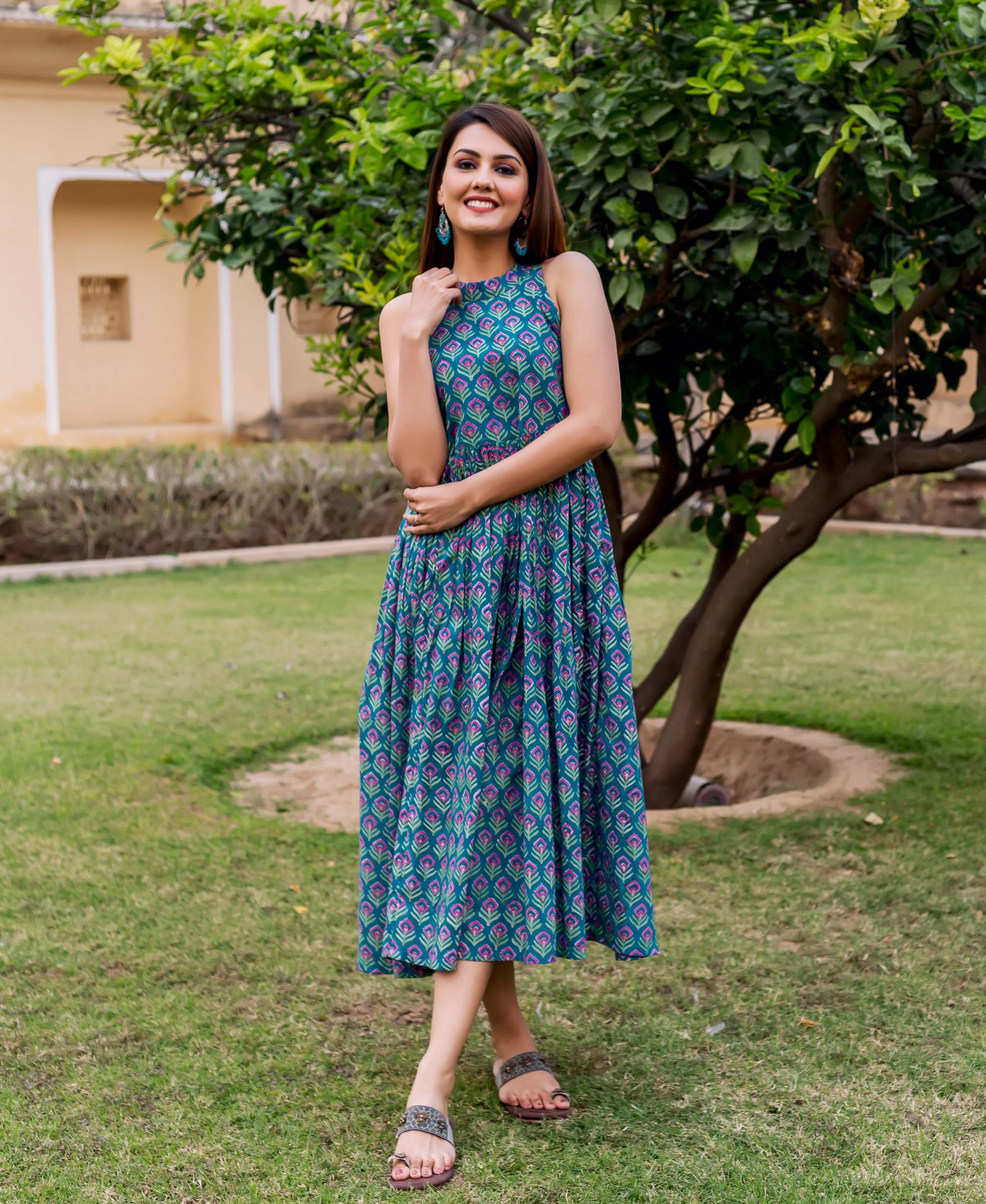 Smiling woman in full-length teal and purple hand block printed halter neck dress.