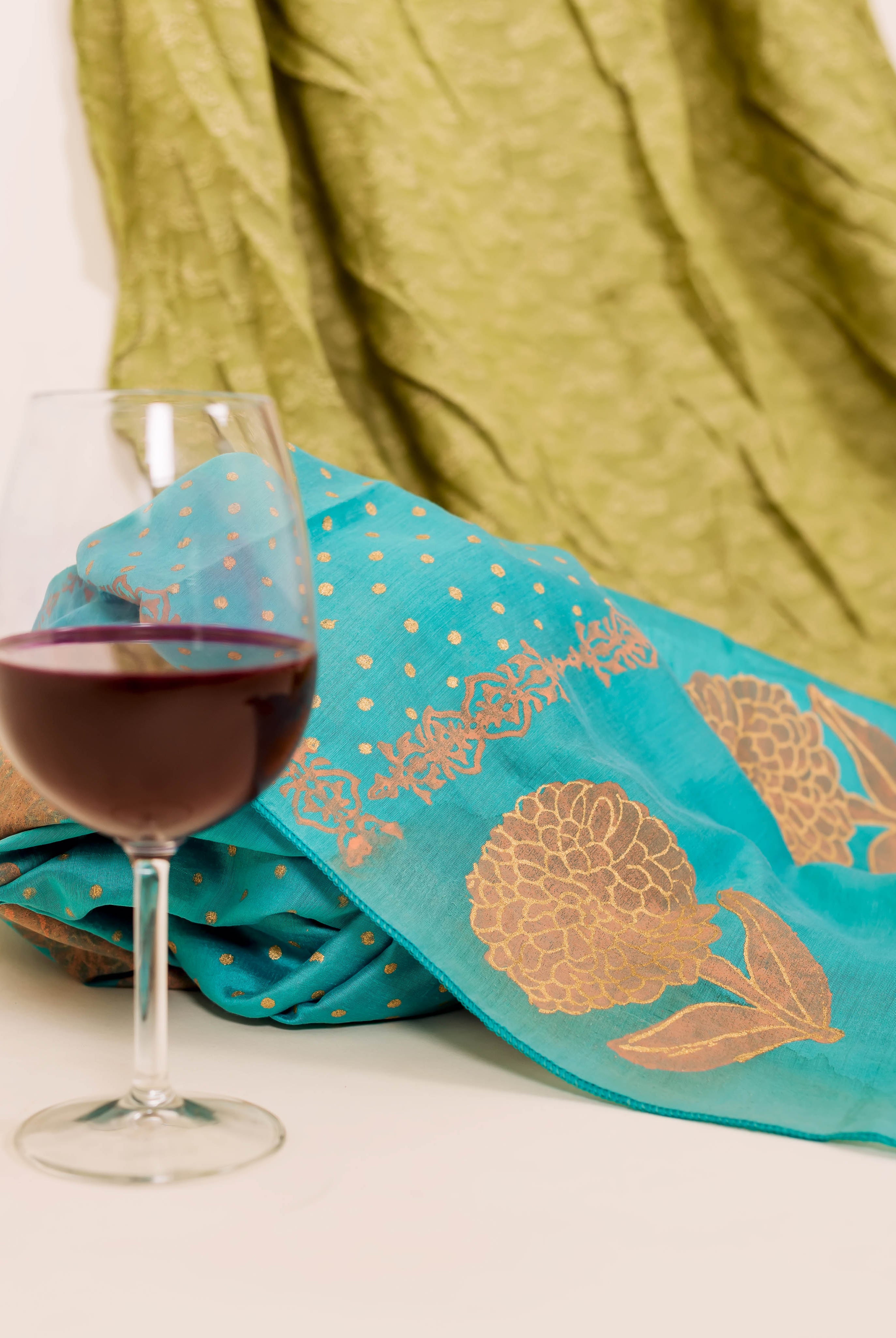 Flat-lay of turquoise dupatta with peach block print.