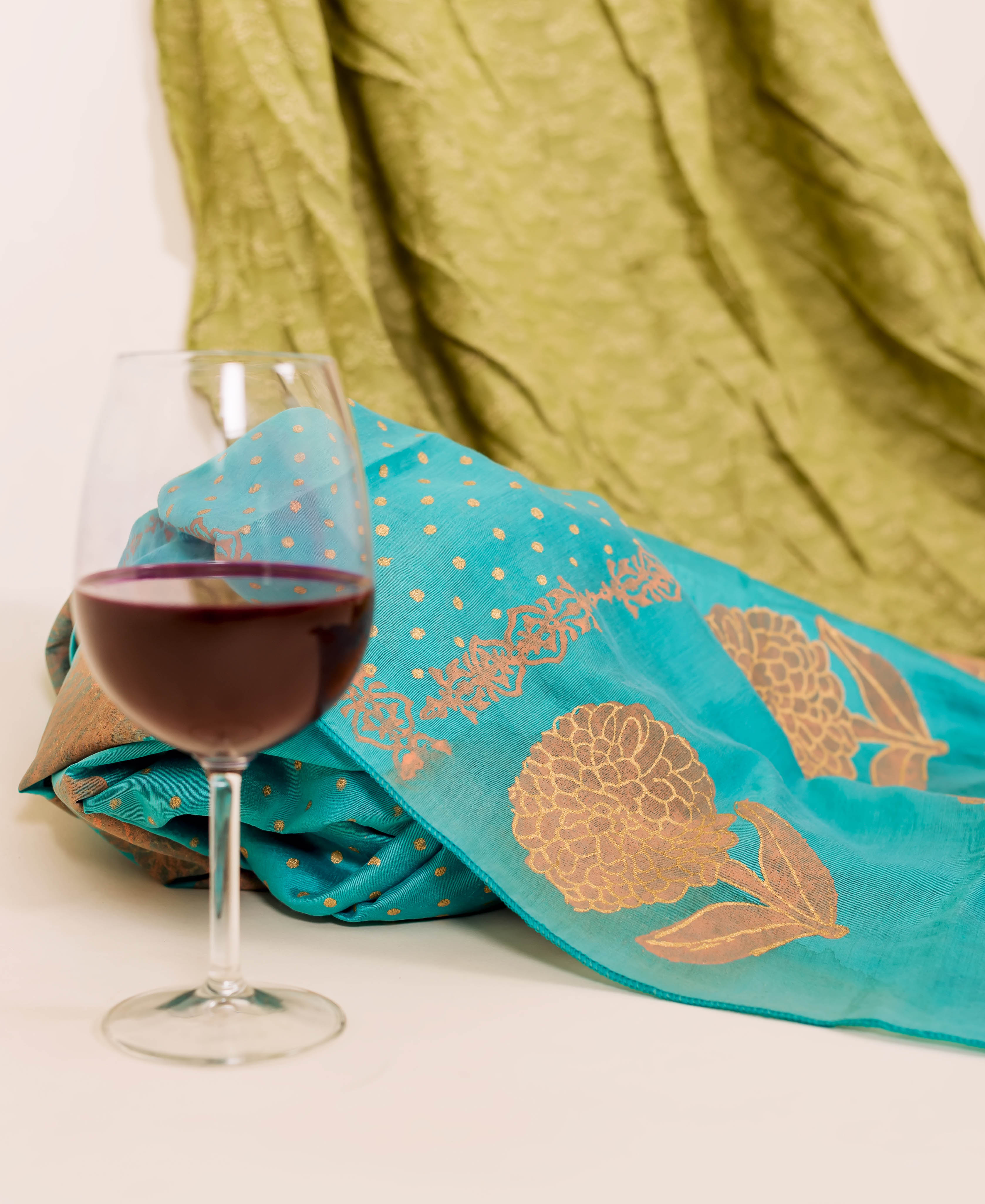 Flat-lay of turquoise dupatta with peach block print.