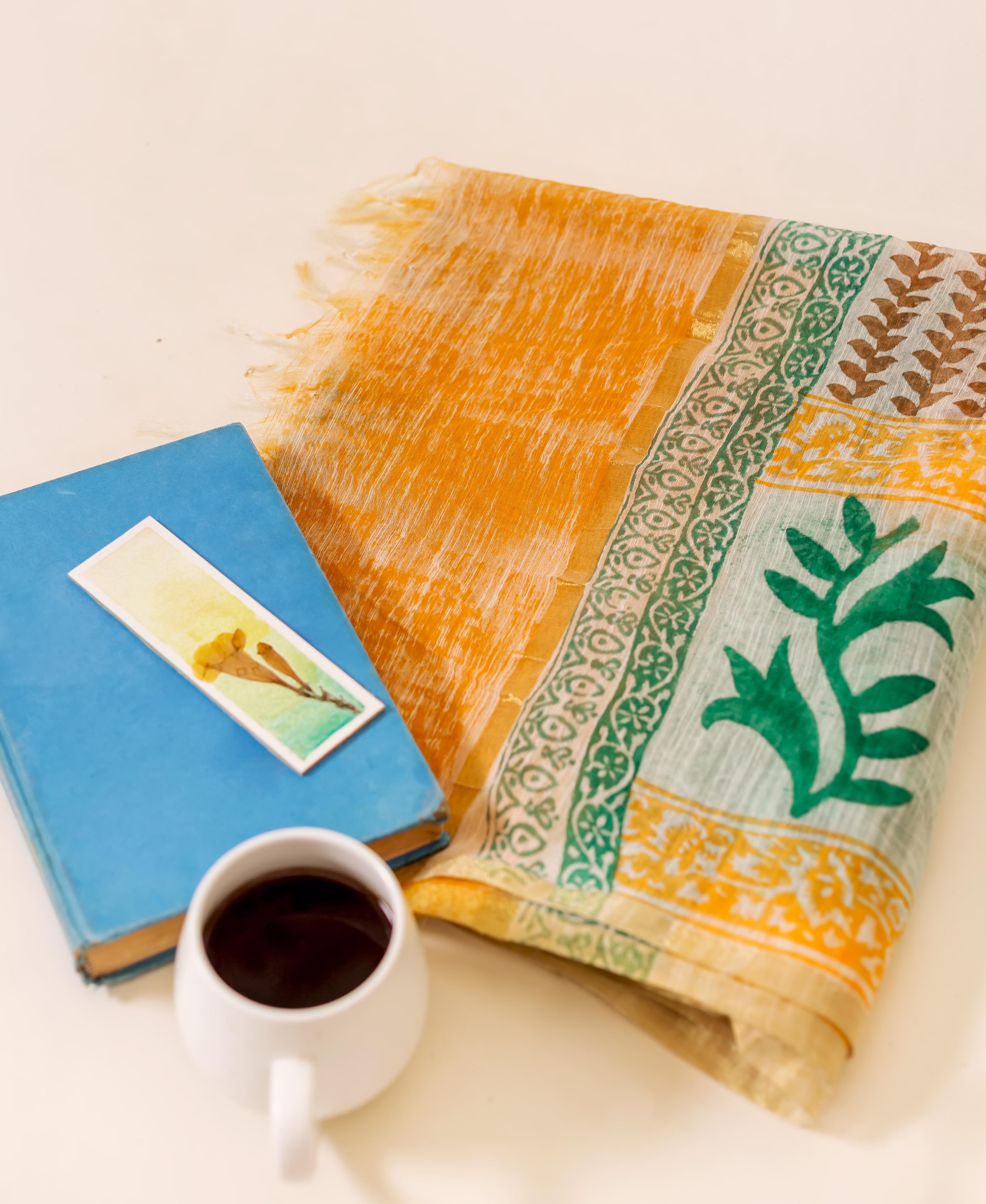 Flat lay yellow and green ruffled dupatta with hand-block-printed ethnic floral patterns.