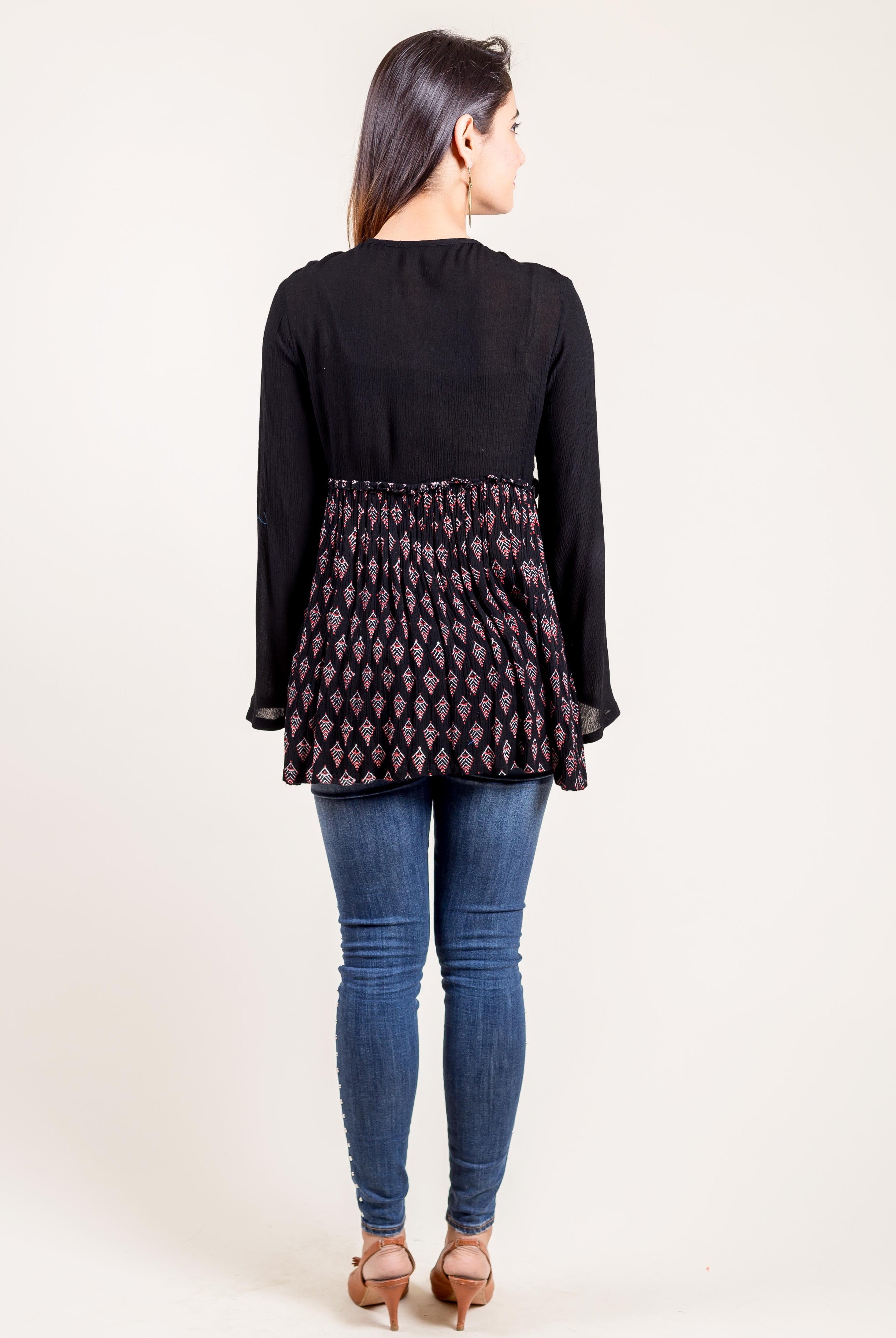 Model from back wearing black tunic top with hand-block-printed ethnic pattern.