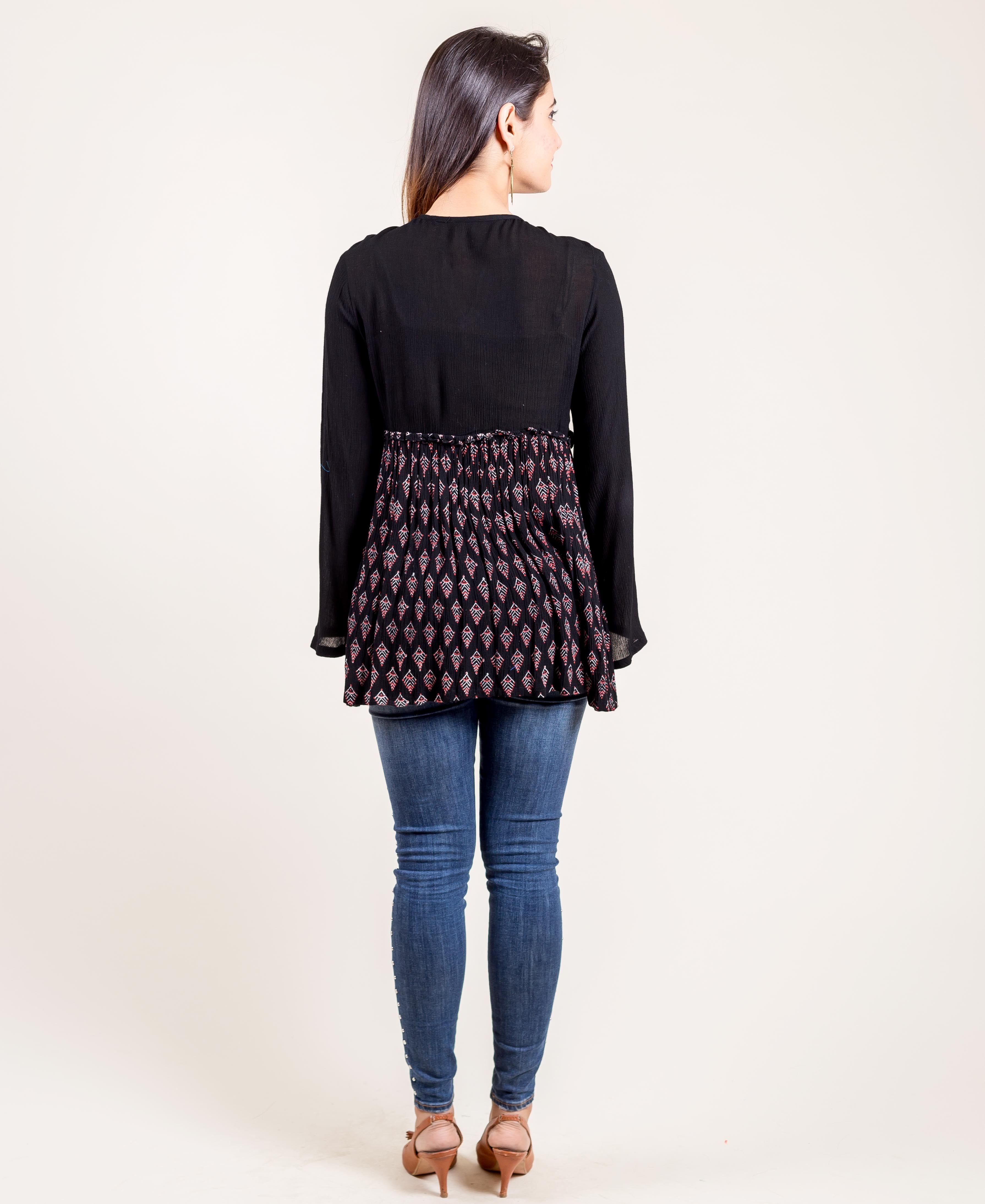 Model from back wearing black tunic top with hand-block-printed ethnic pattern.
