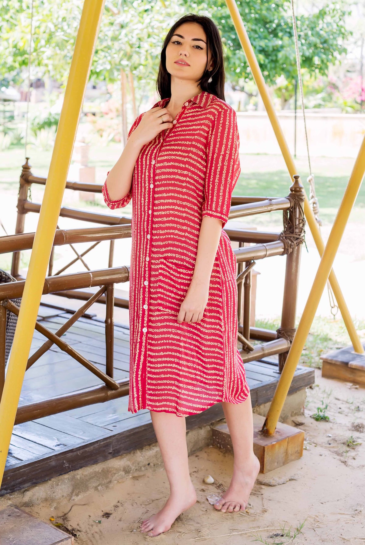 Front full look of a model in a coral block-printed button-down dress.