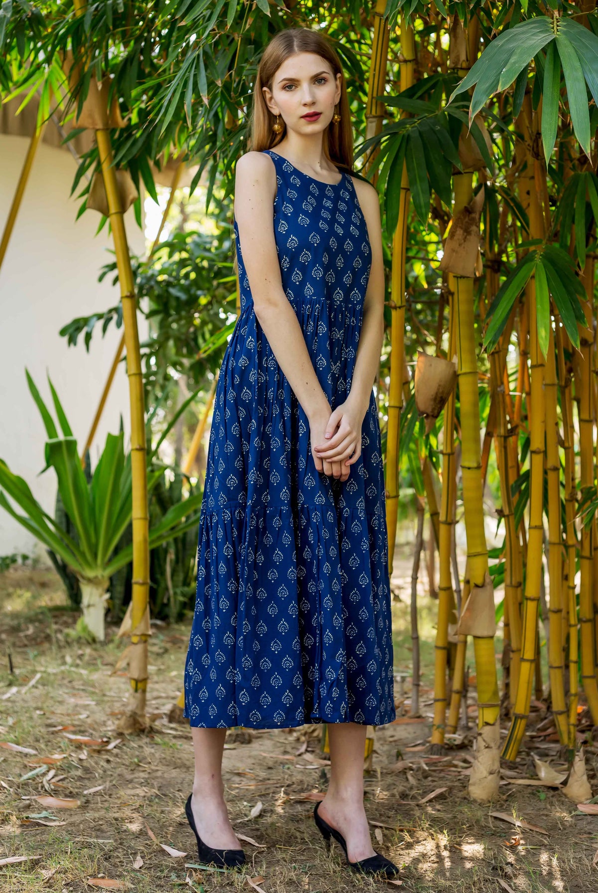 Front full look of model wearing indigo hand block printed sleeveless tiered dress.