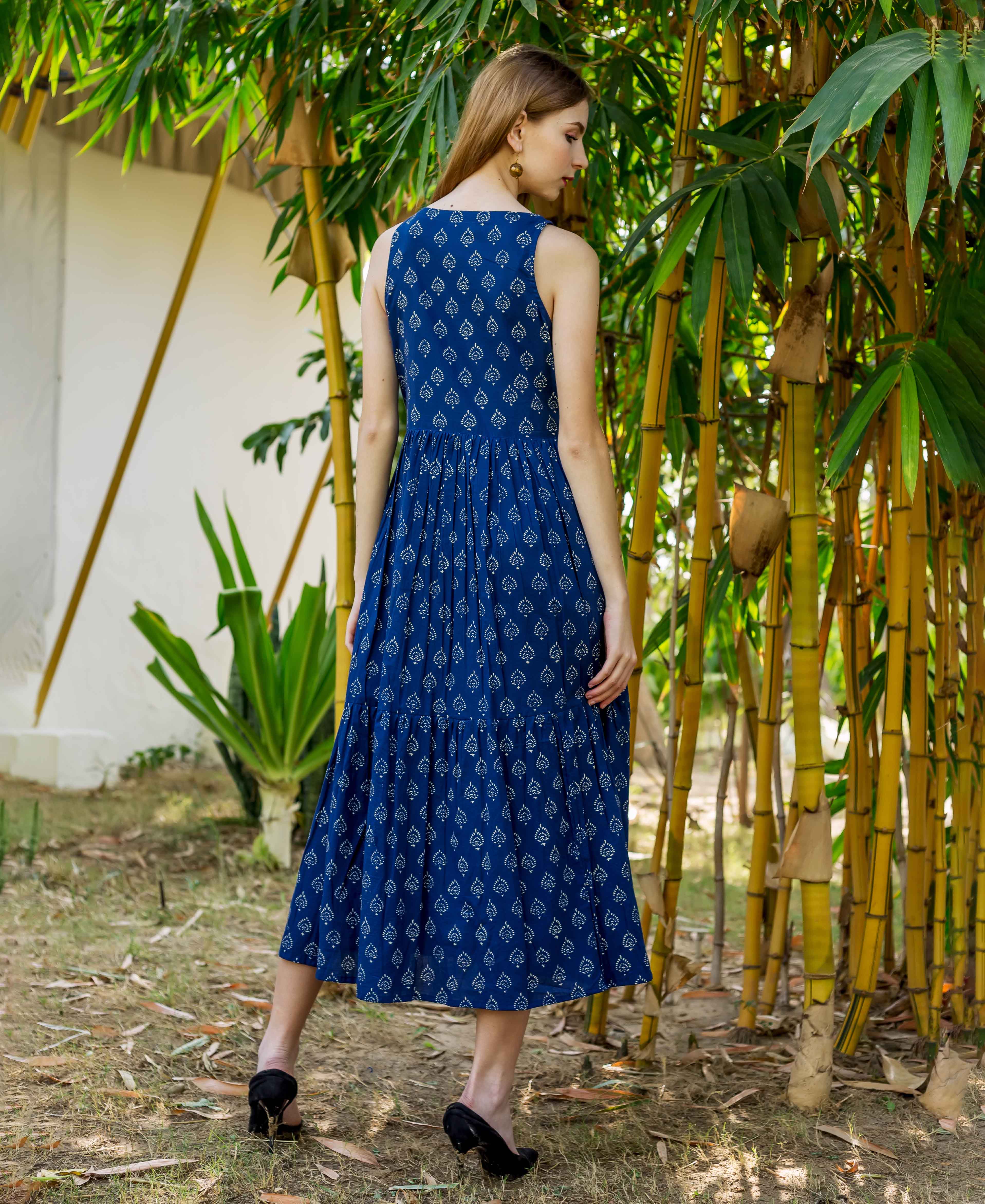 Back view of model wearing indigo hand block printed sleeveless tiered dress.