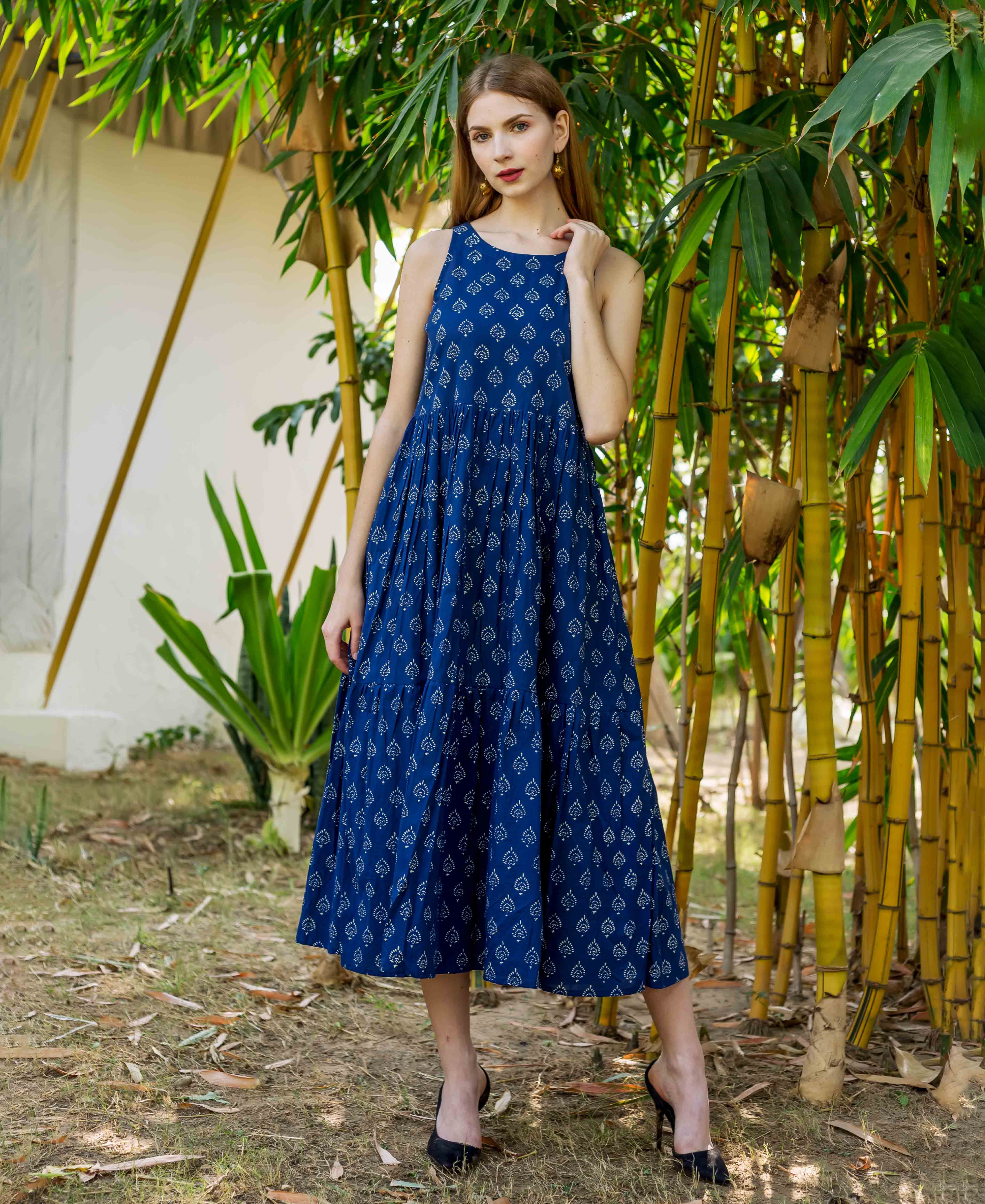 Full-length model wearing an indigo hand block printed sleeveless tiered dress.