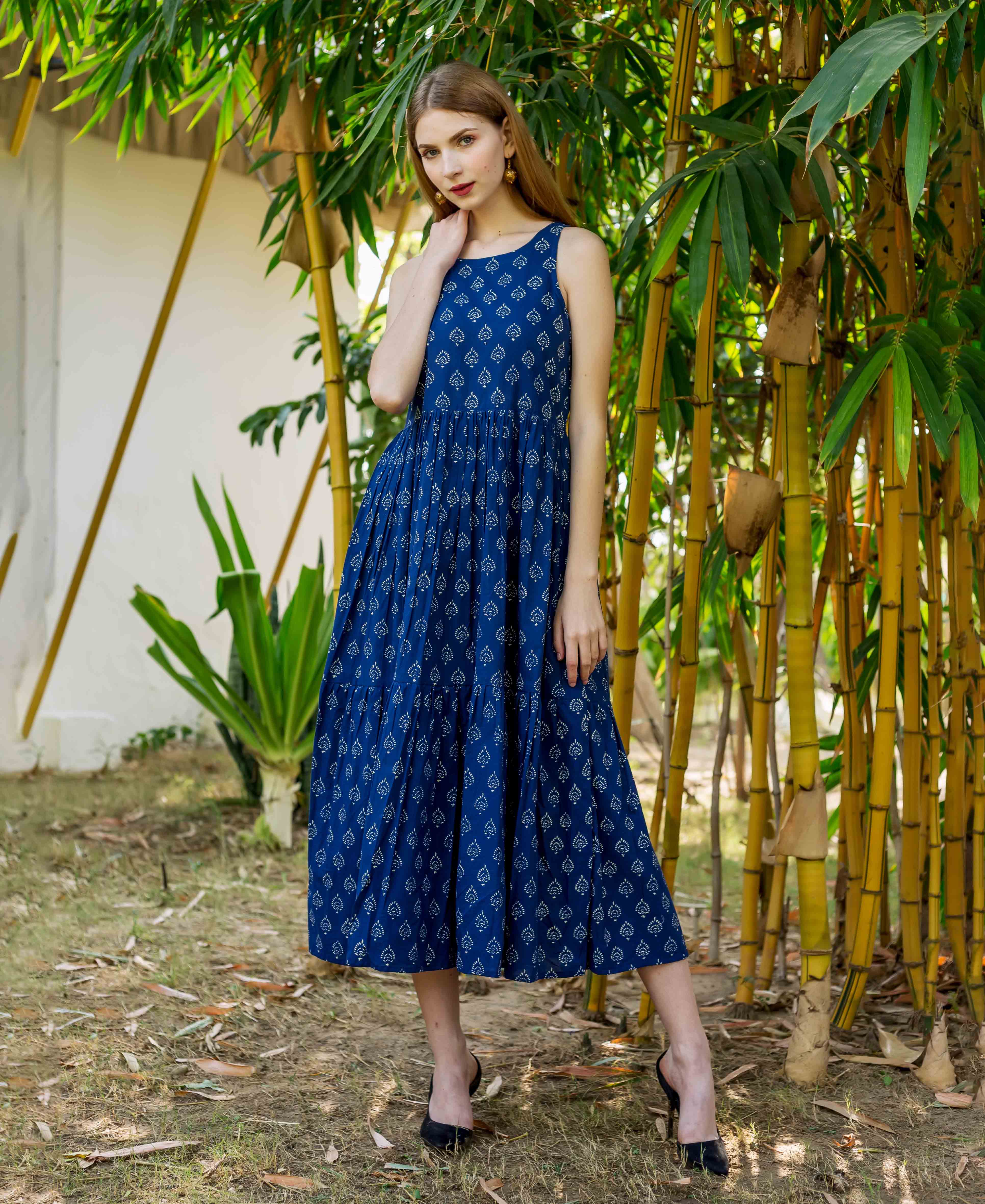 Front view of model wearing full indigo blue sleeveless tiered dress with white hand block print.