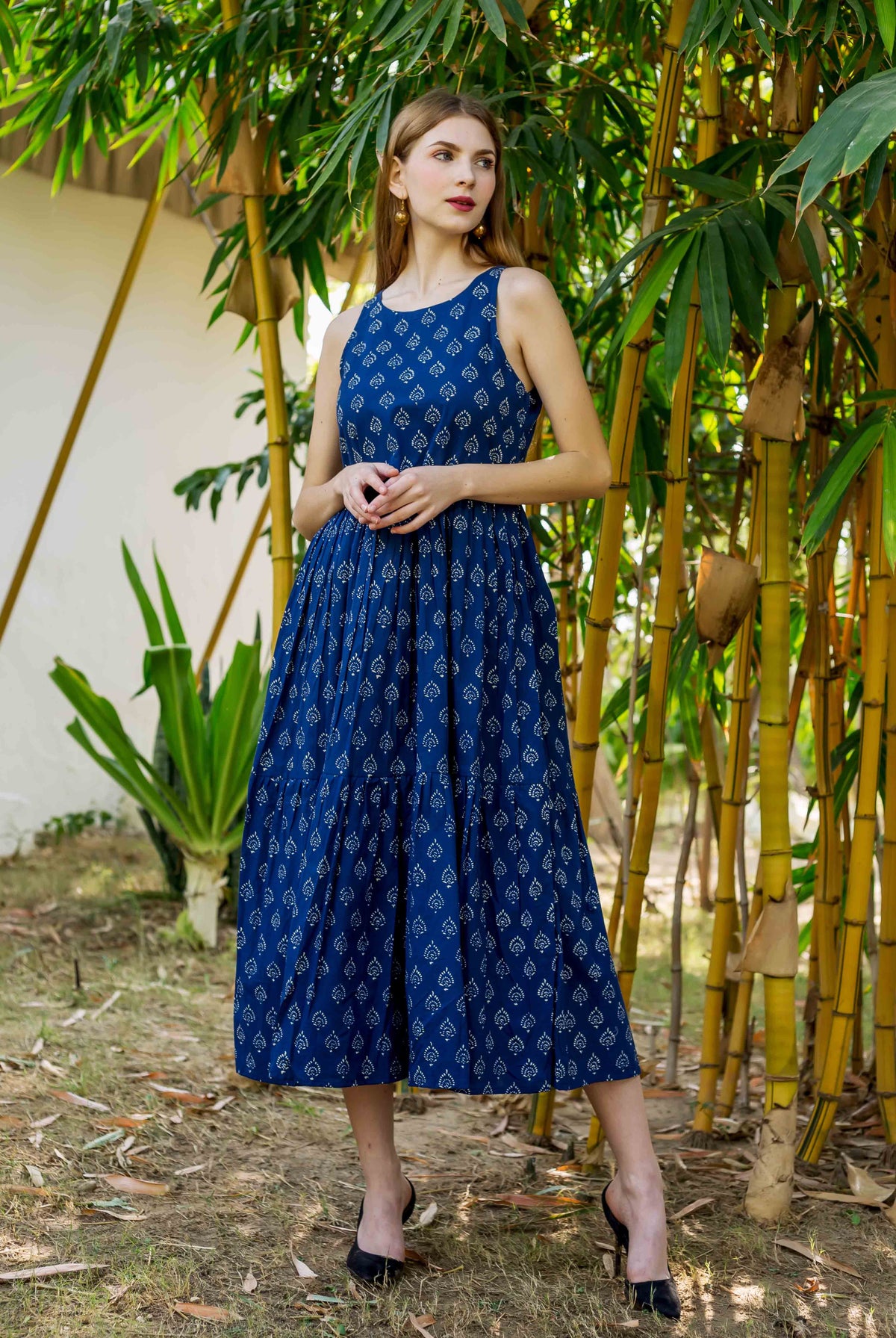 Front view of model in indigo hand block printed sleeveless tiered dress.