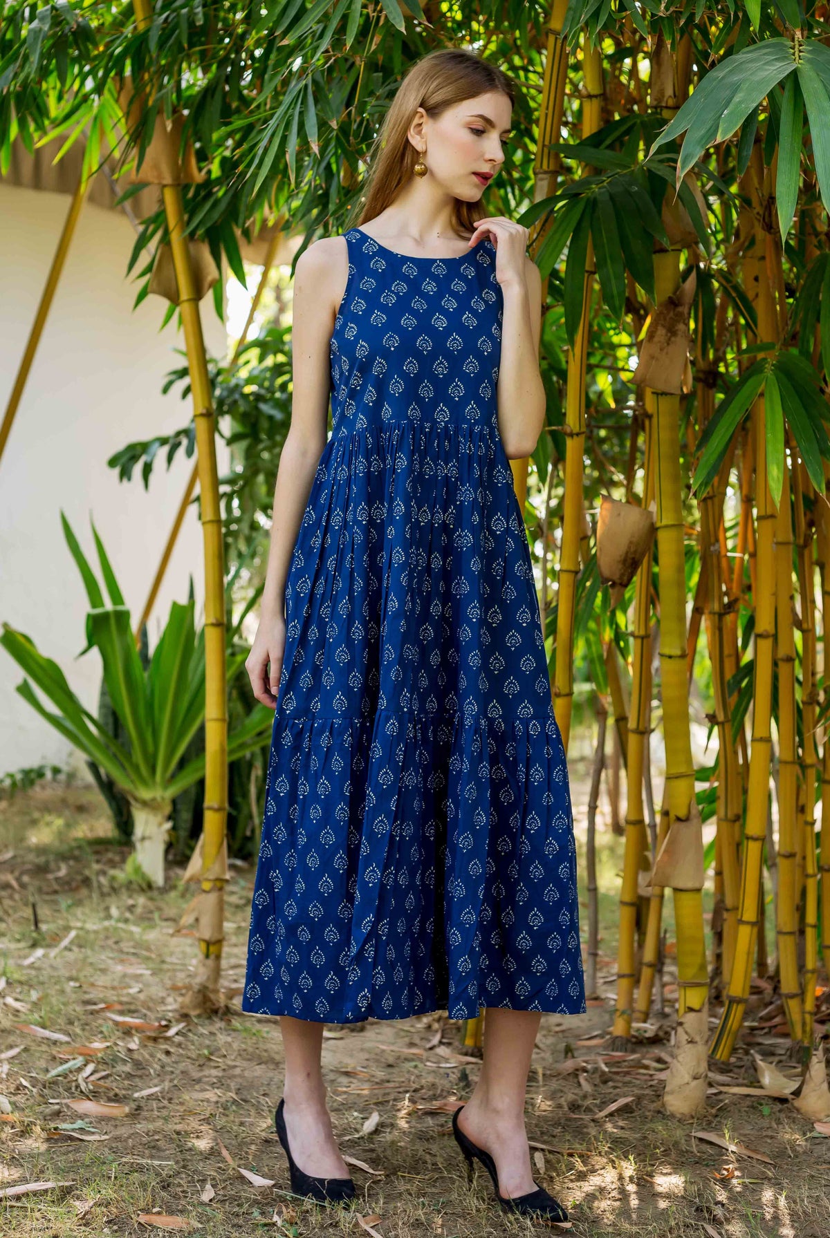 Model in full look of indigo hand-block printed sleeveless tiered dress.