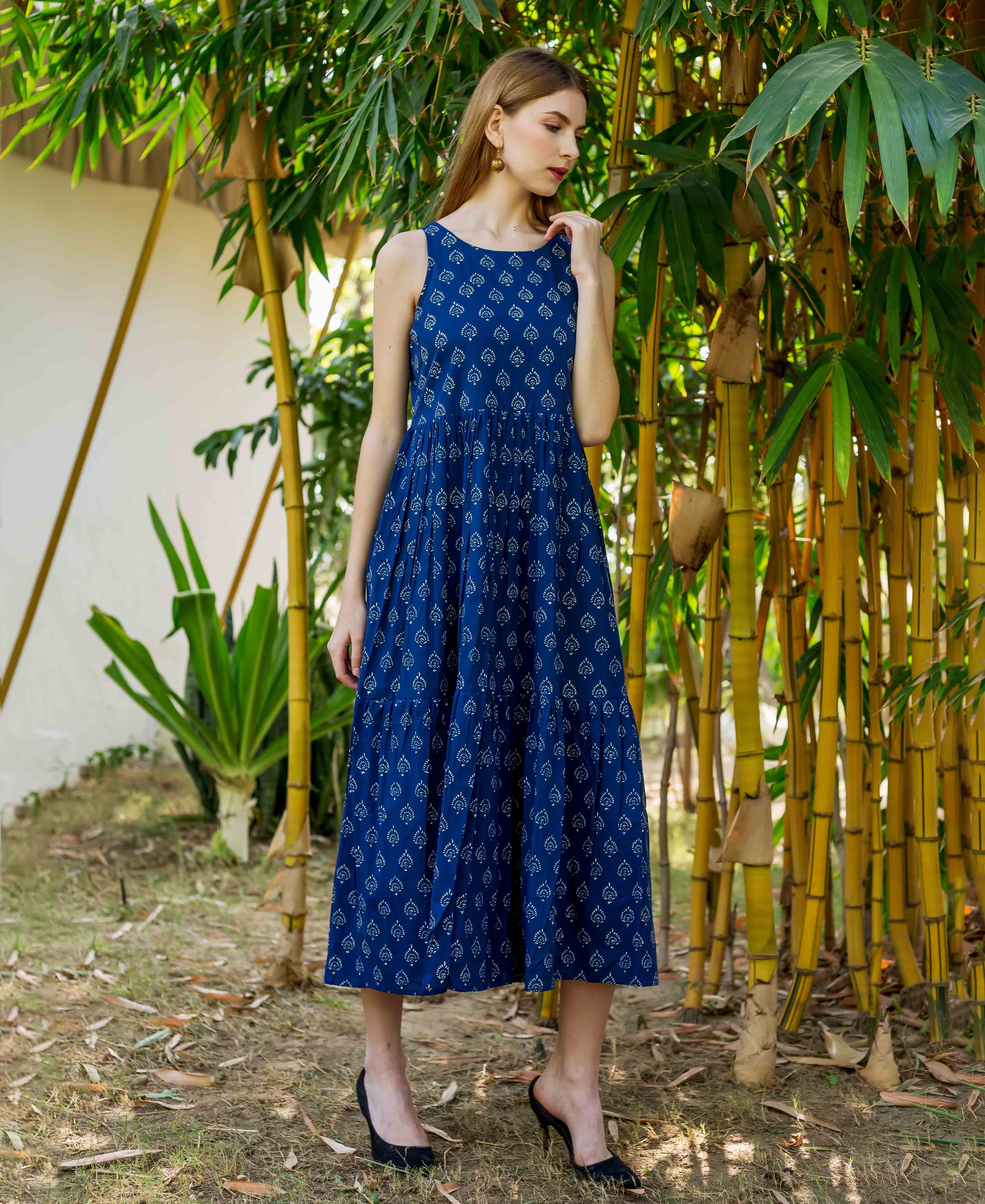 Model in full look of indigo hand-block printed sleeveless tiered dress.