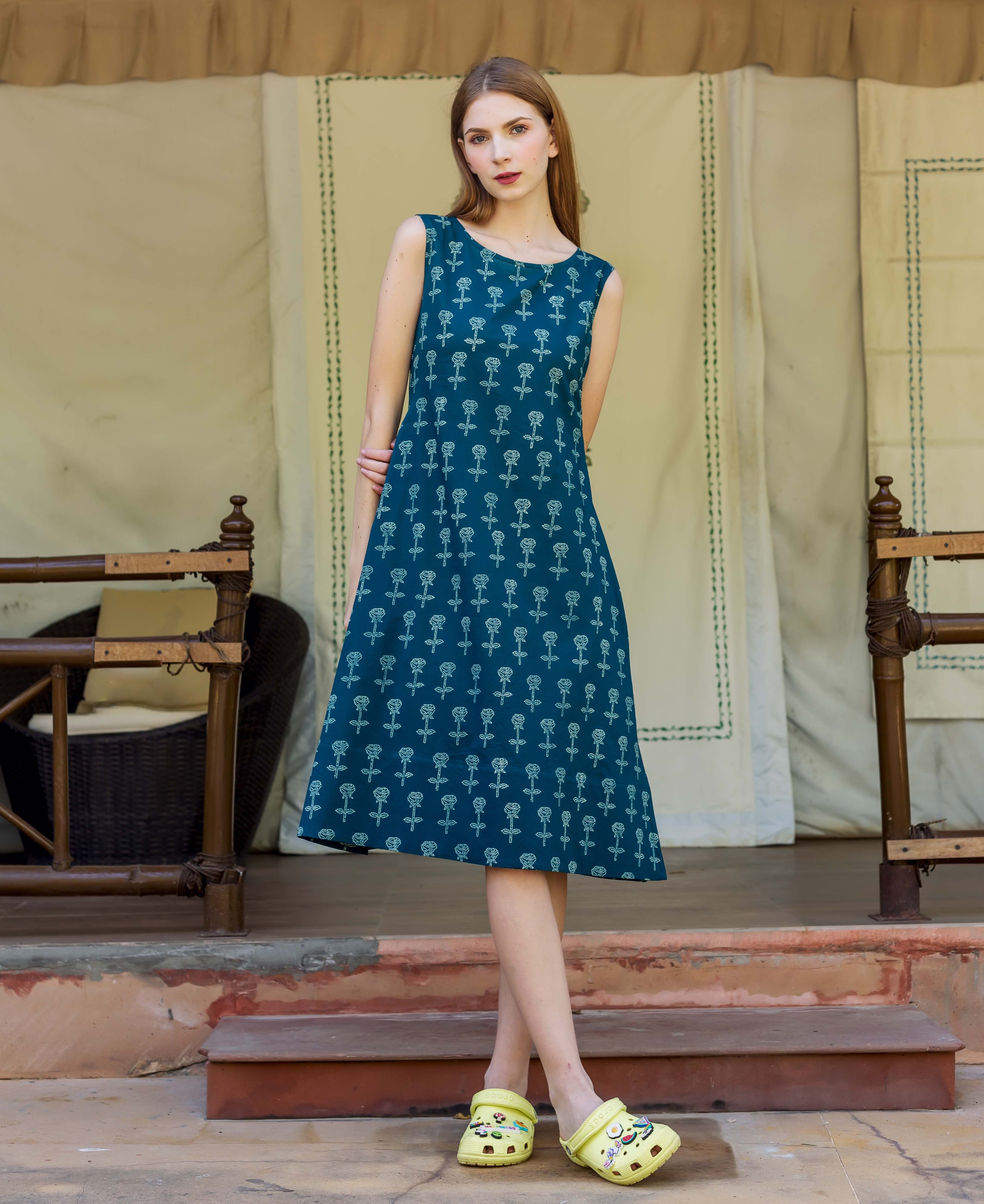 Model wearing sleeveless deep teal A-line dress with white hand-block floral motifs.