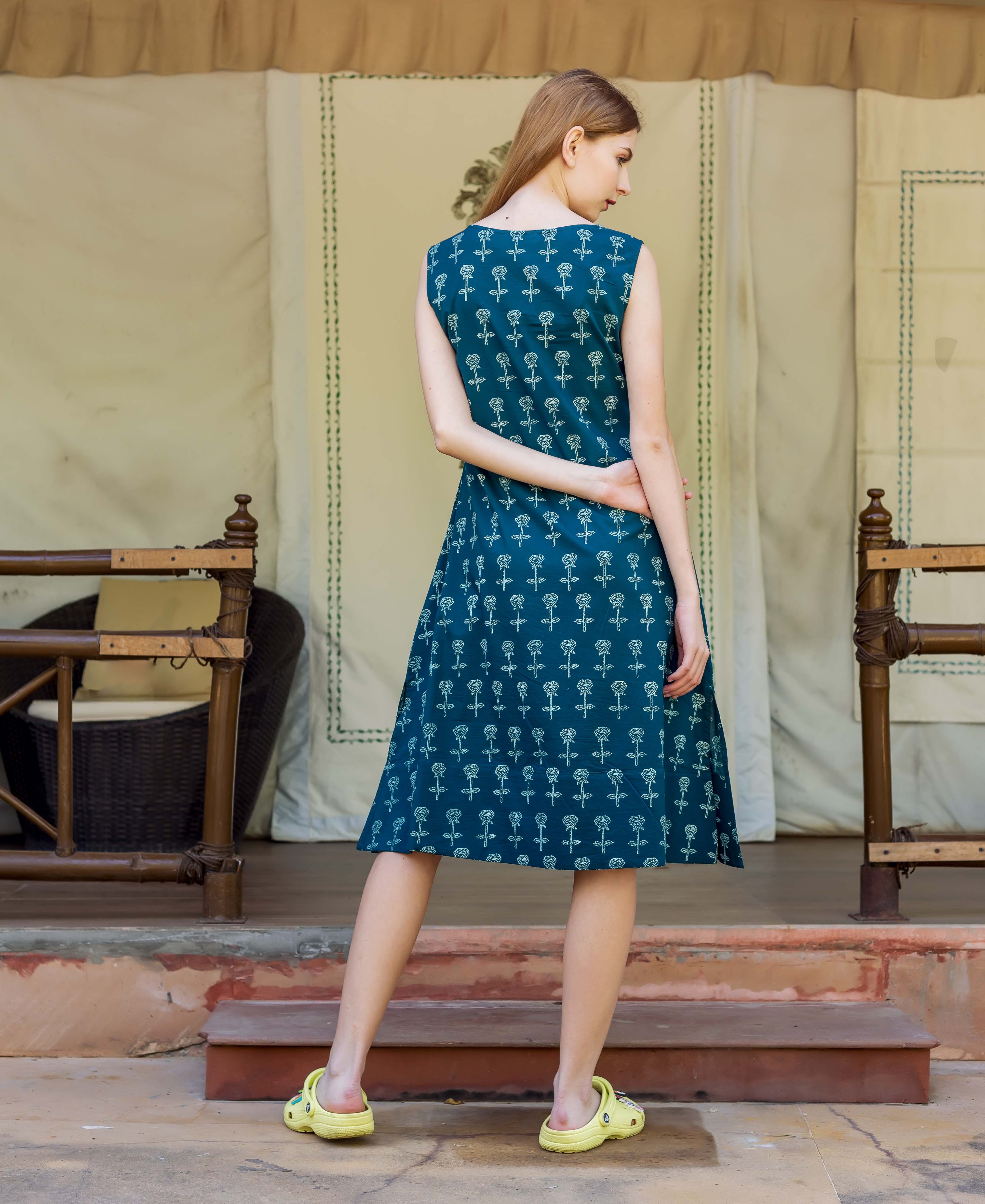 Model from back wearing dark teal sleeveless A-line dress with white hand-block floral print.