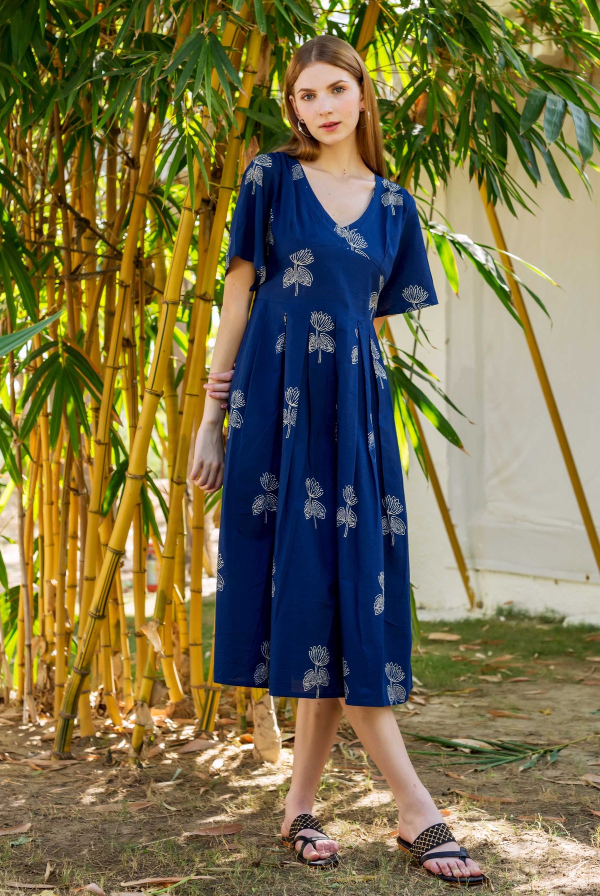 Front view of a model in an indigo hand-block-printed dress with white lotus patterns.