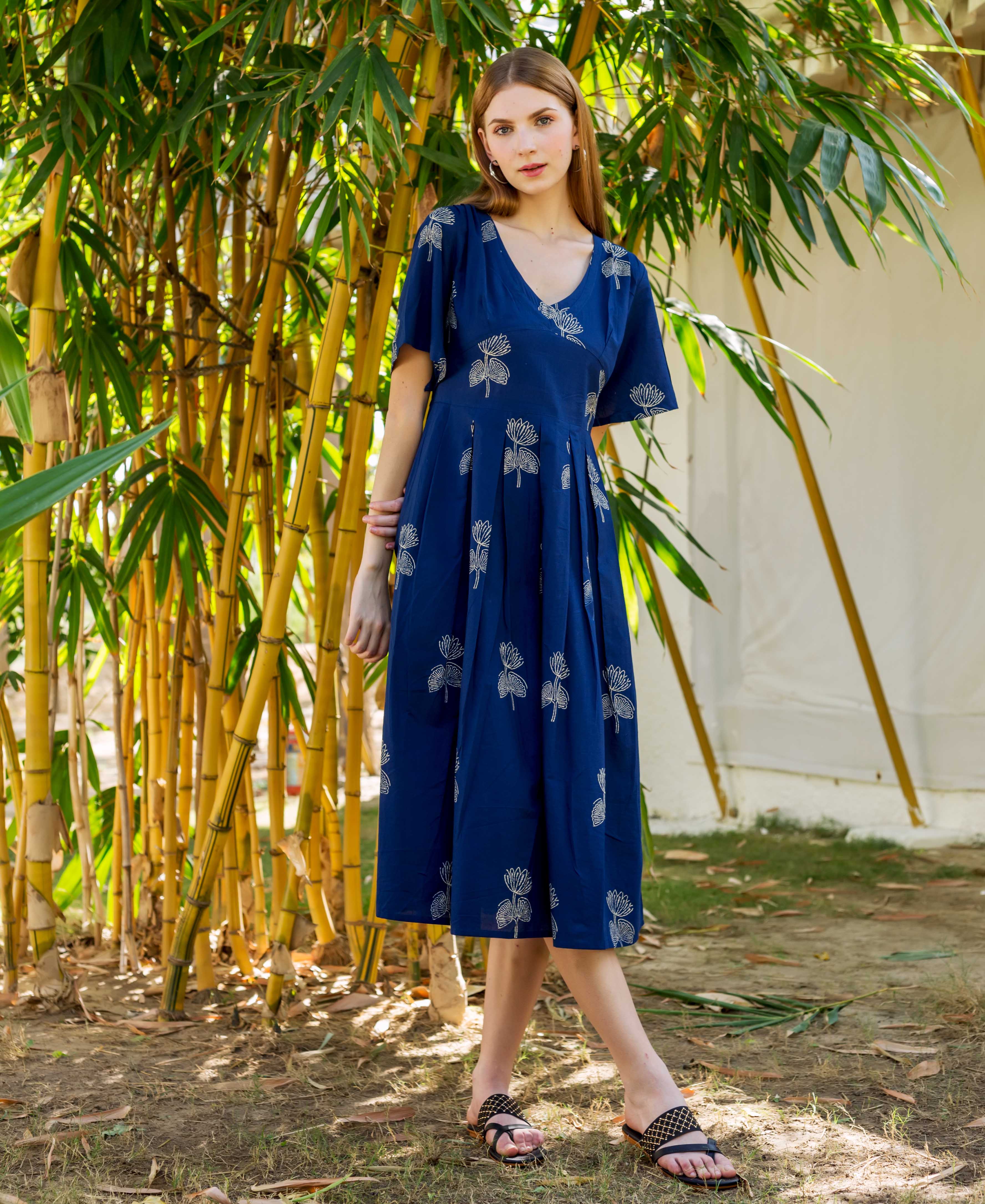 Front view of a model in an indigo hand-block-printed dress with white lotus patterns.