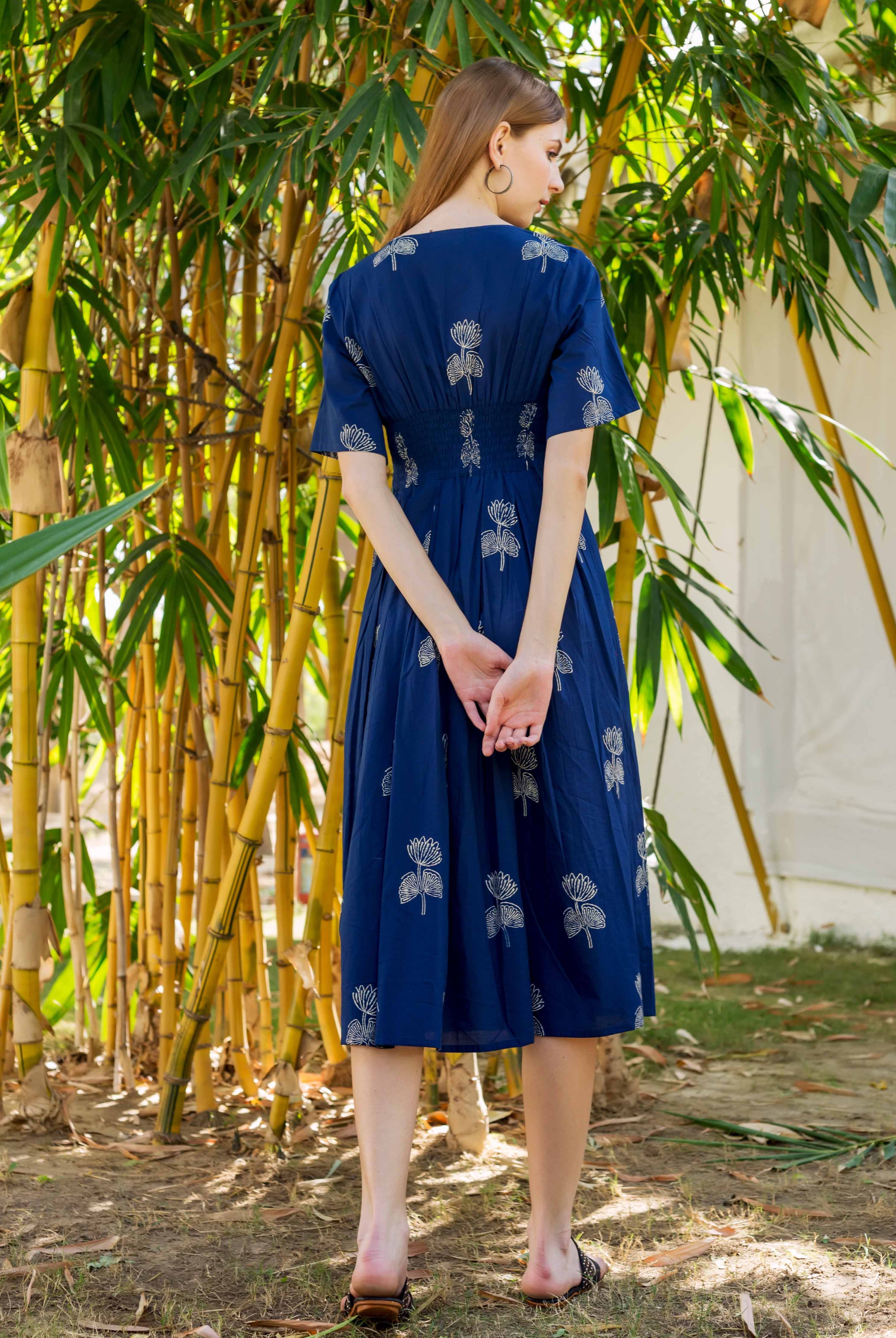Model's back in indigo midi dress with intricate white floral block print.