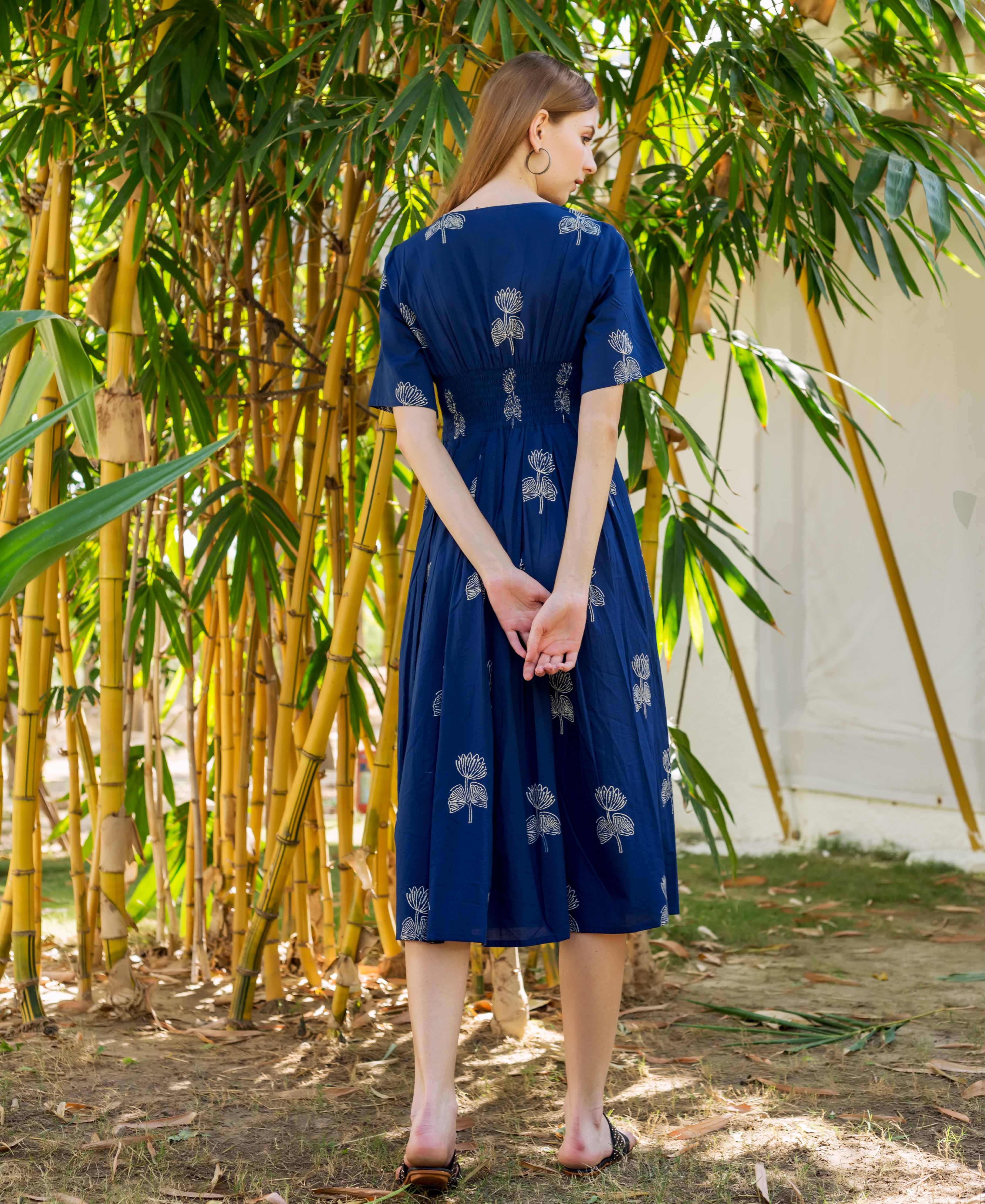 Model's back in indigo midi dress with intricate white floral block print.