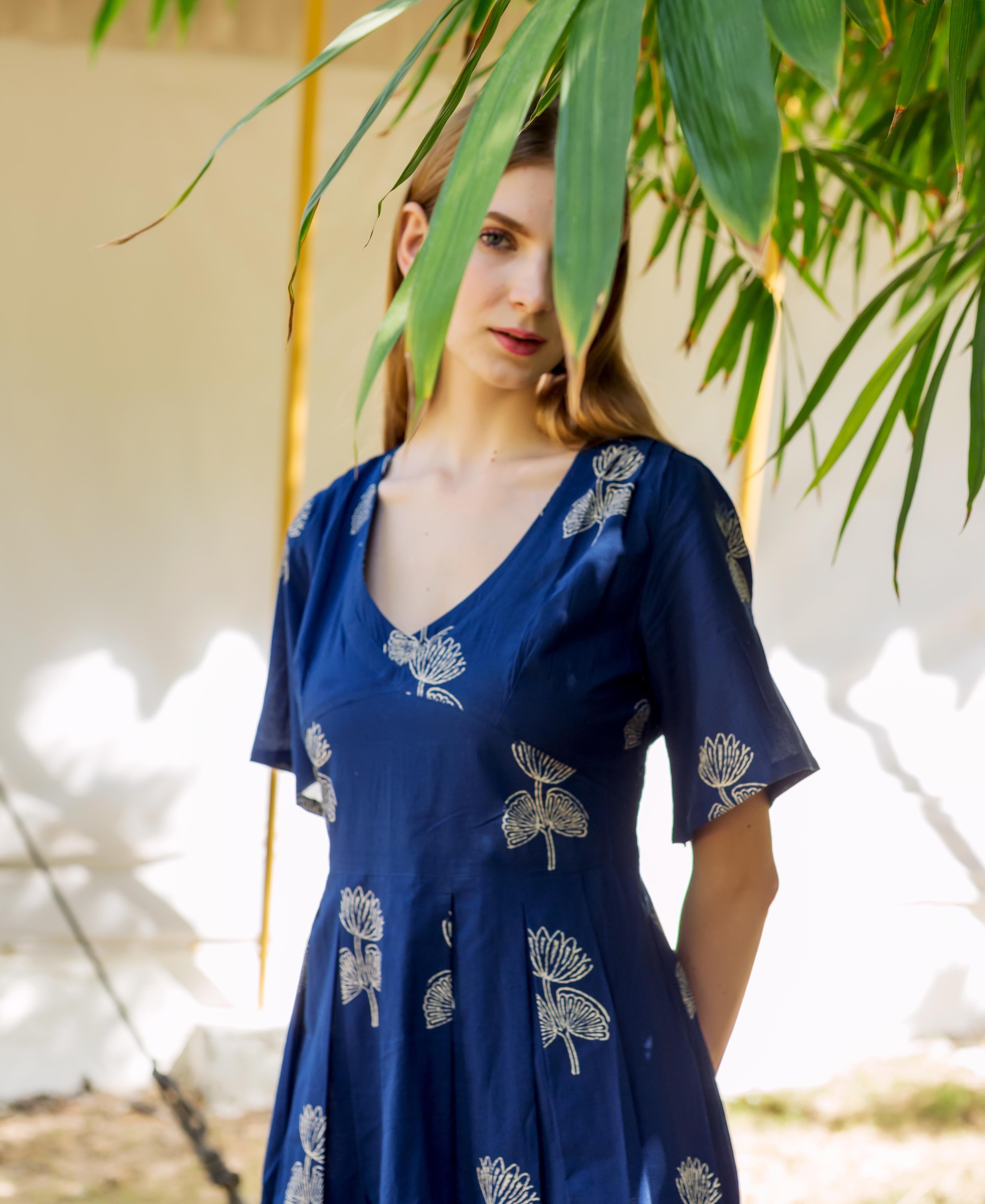 Model wears indigo blue V-neck dress with cream hand-block botanical print.