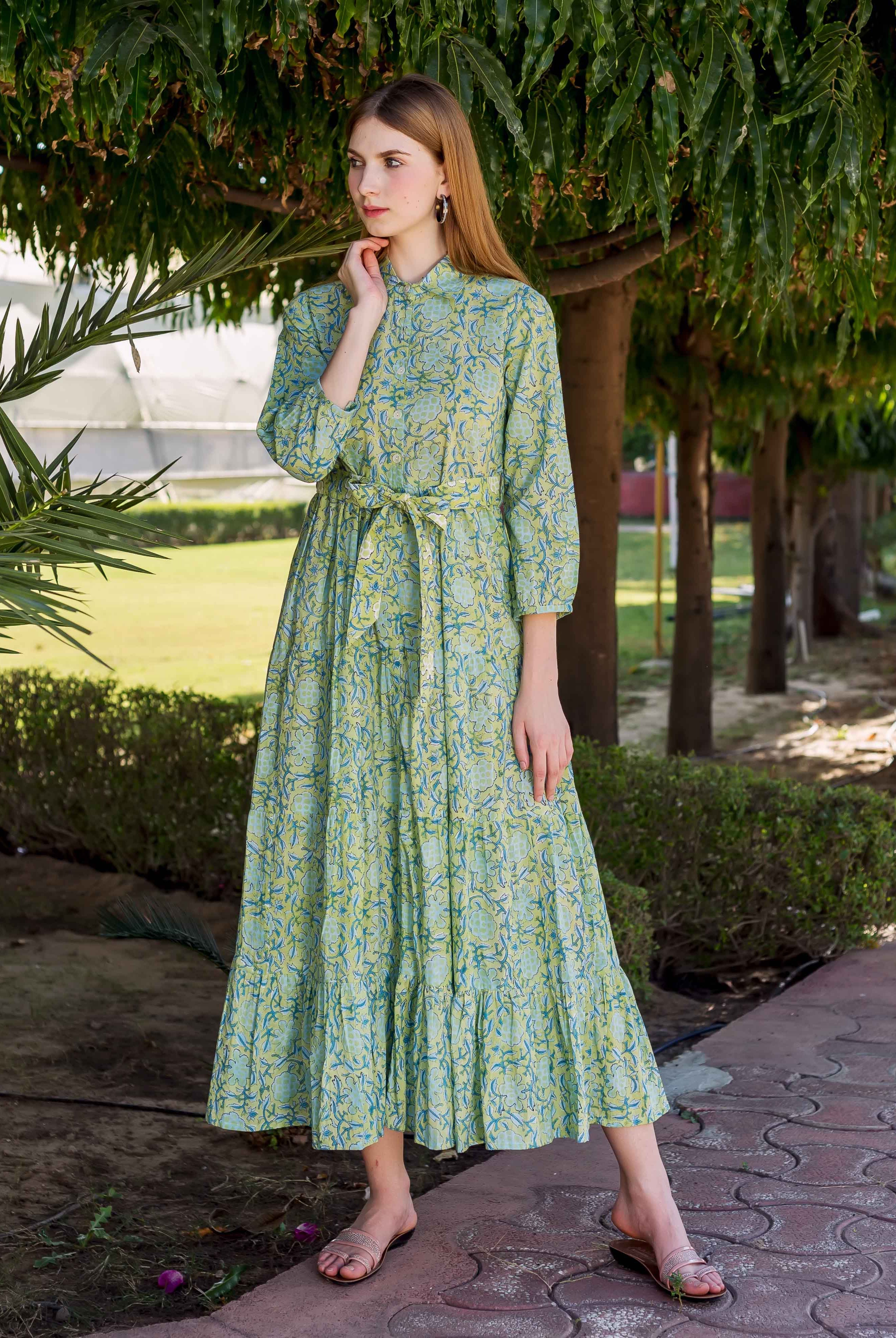A model wearing a lime green, hand-block-printed dress with a shirt collar and floral pattern.