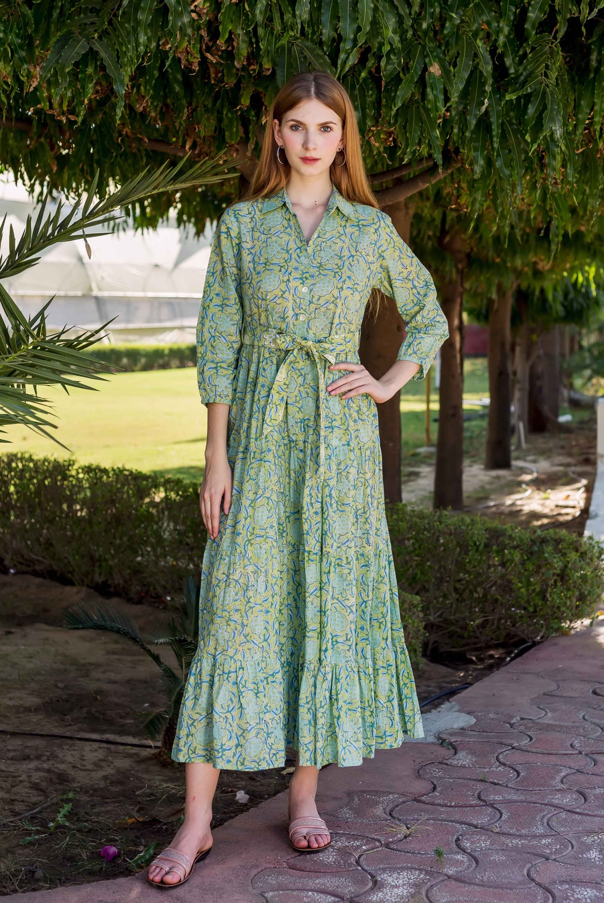 A model wearing a lime green, blue and white floral print dress.
