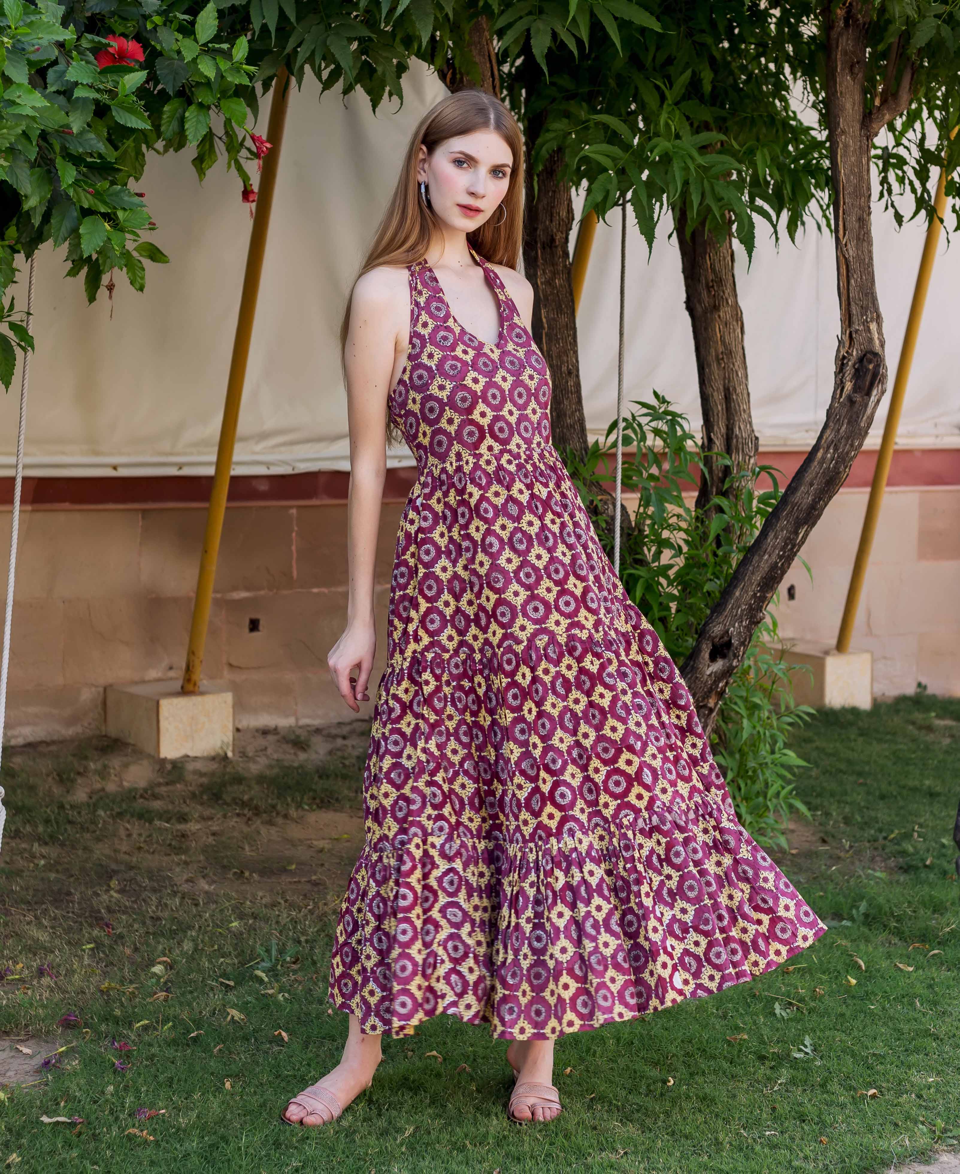 Model in wine and yellow geometric hand-block-printed halter neck tiered maxi dress.