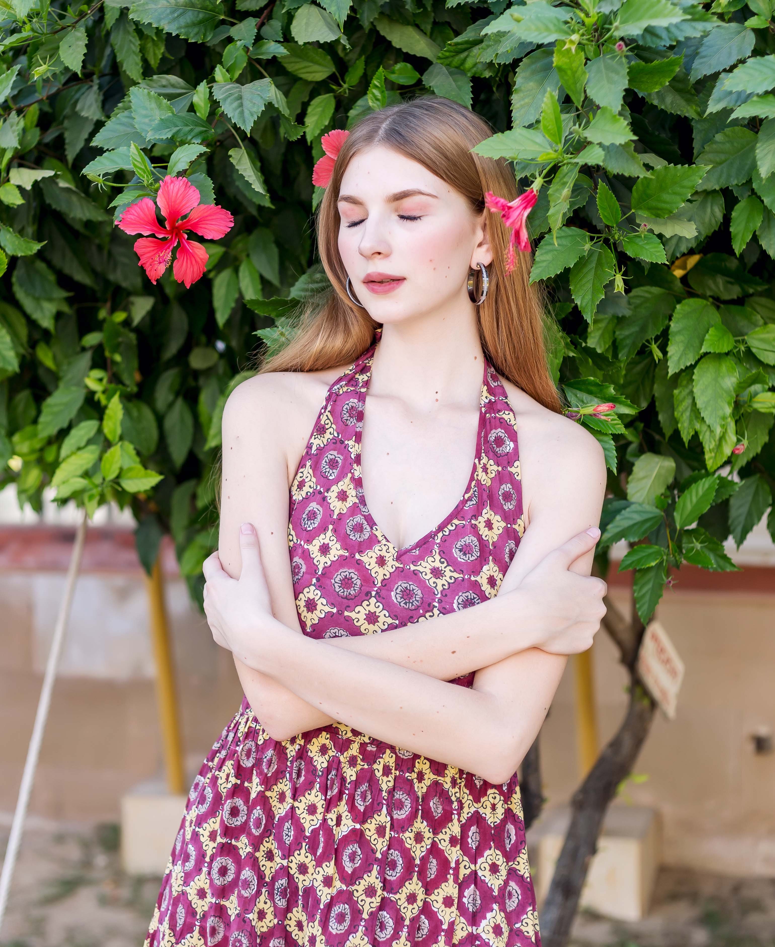 Model wearing a front view wine halter neck dress with yellow ethnic hand-block print.