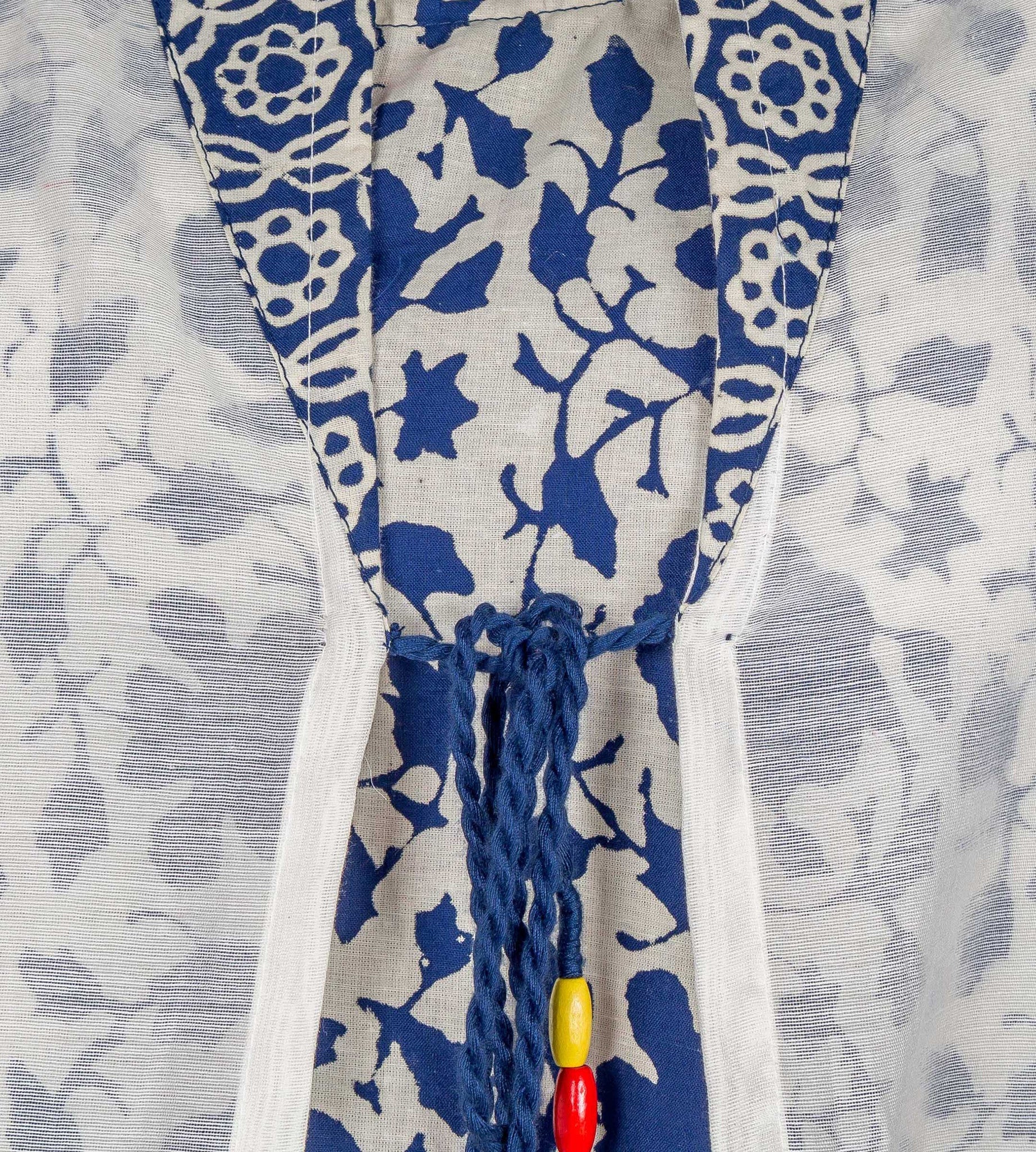 Close-up of blue and white floral hand-block-printed kurta with a decorative beaded tie.