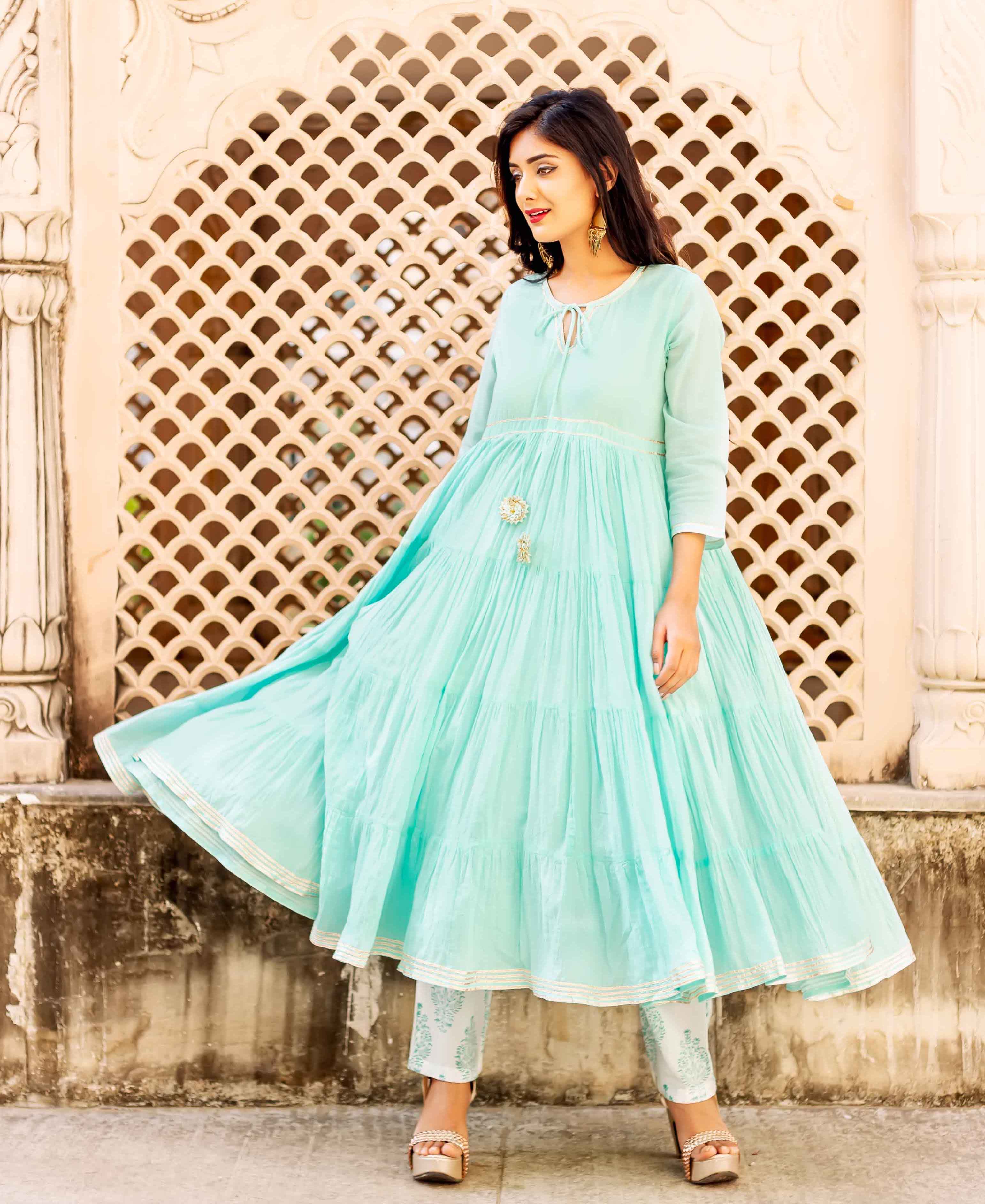 Full length model in flowing aqua blue tiered kurta and white hand-block printed pants.