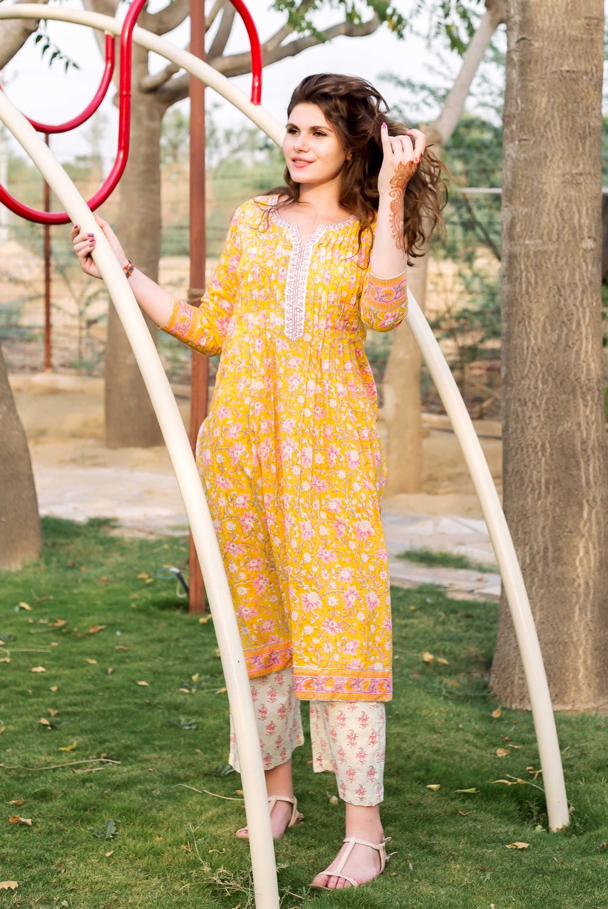 Model wears a yellow straight-cut Jaal block printed kurta with cream printed pants.