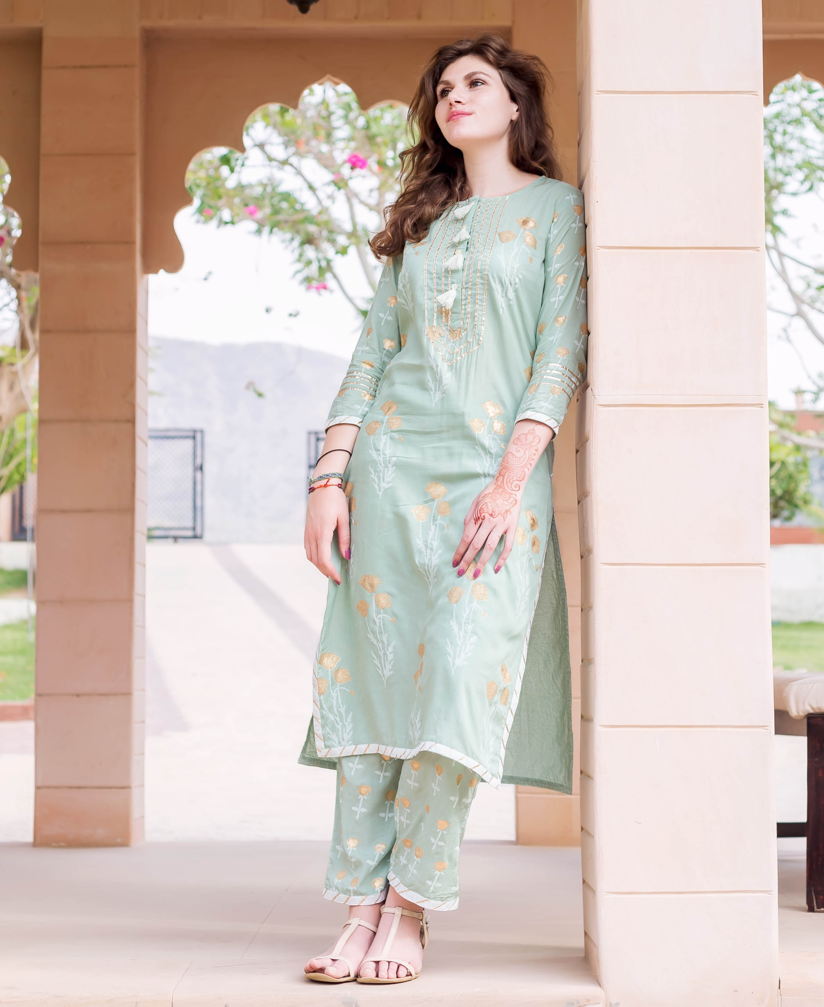 Model in a mint green hand-block-printed cotton kurta set with golden floral designs.