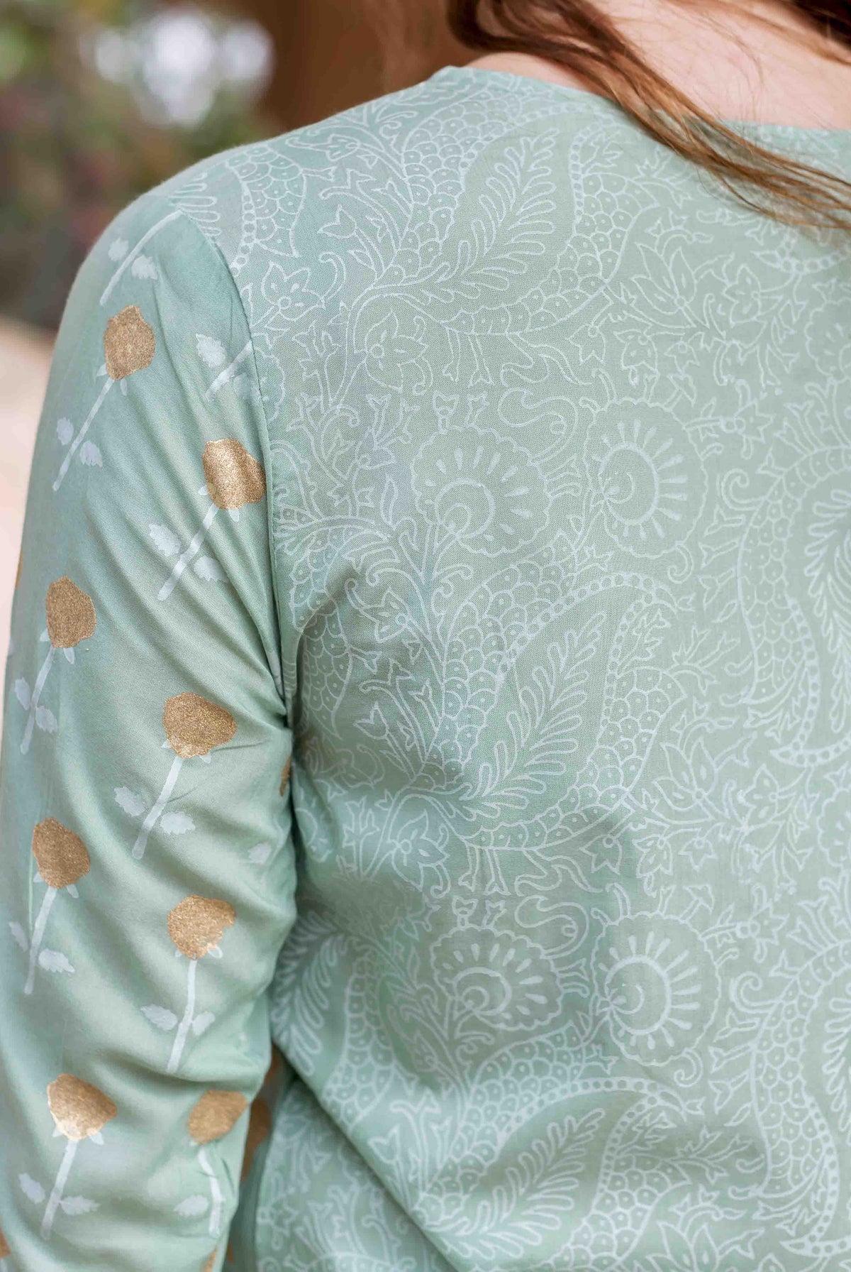 Mint green kurta with white patterned back and gold floral block prints on sleeve.