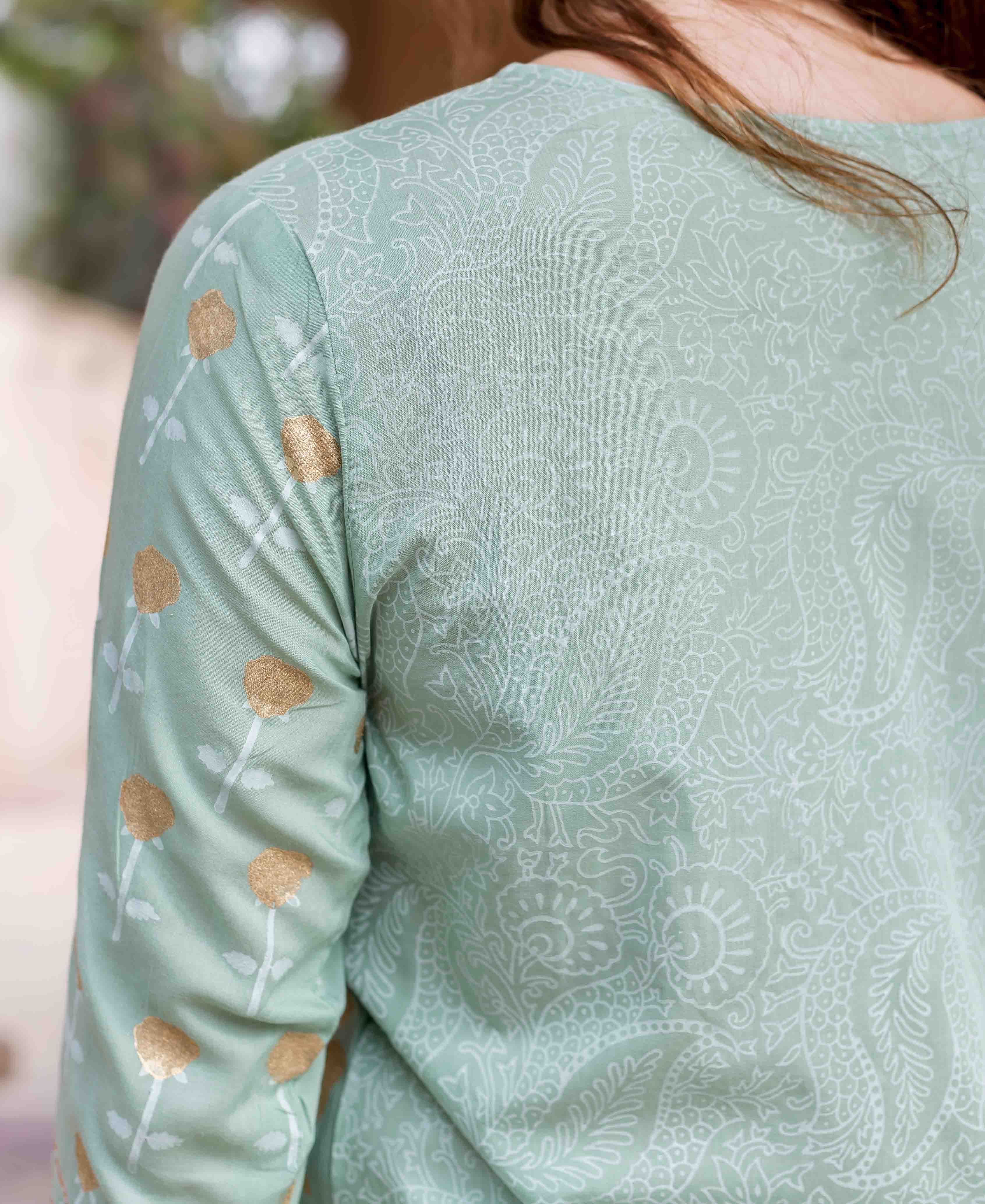 Mint green kurta with white patterned back and gold floral block prints on sleeve.
