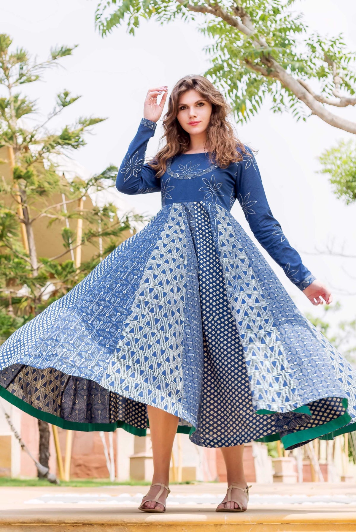 A model wearing a blue and white hand-block-printed flared long dress.