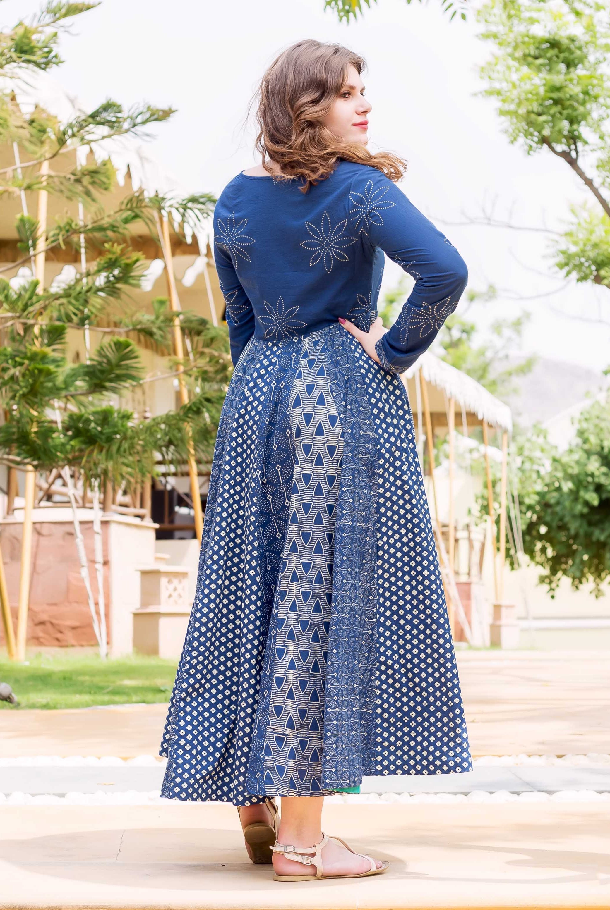 Model from back/side in indigo and white hand block printed flared long dress with floral and geometric patterns.
