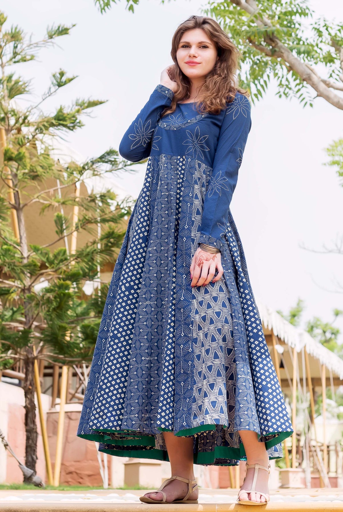 Woman wears indigo and white hand-block printed flared long dress with varied patterns.