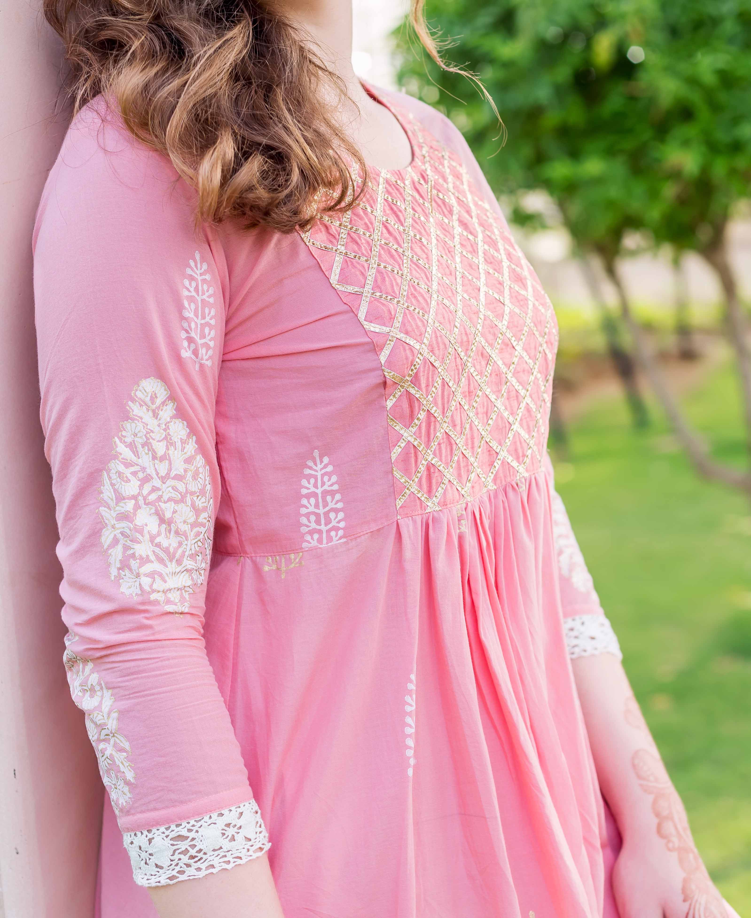 Pink A-line kurta on model, golden embroidered yoke, and white hand-block-printed sleeves.
