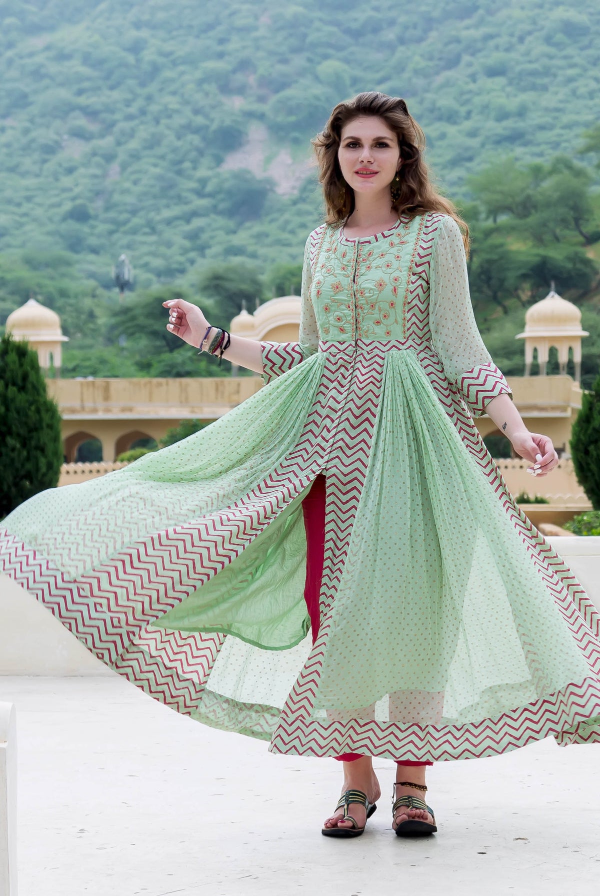 Model in mint green chiffon Anarkali with red zig-zag print, open front, fuchsia trousers.