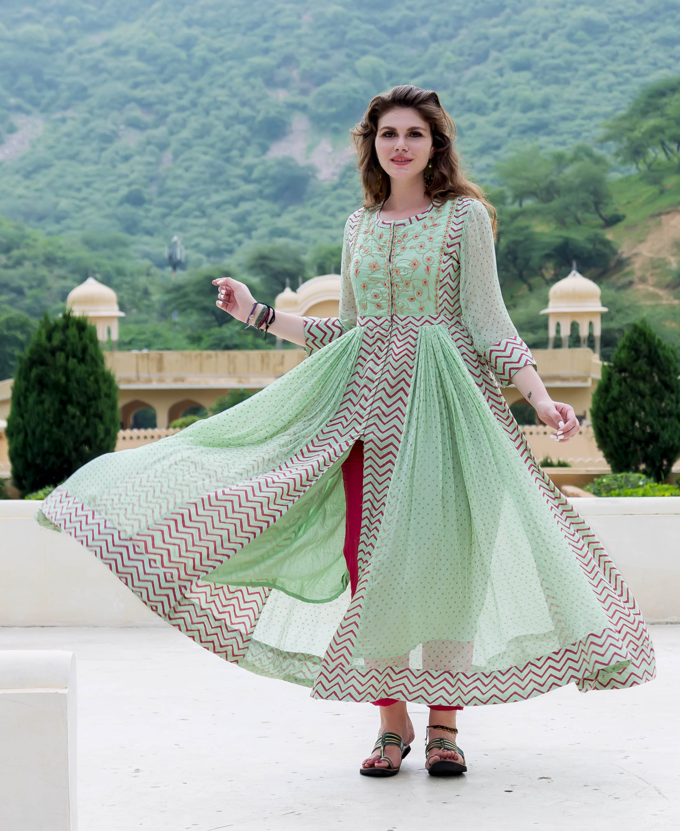 Model in mint green chiffon Anarkali with red zig-zag print, open front, fuchsia trousers.