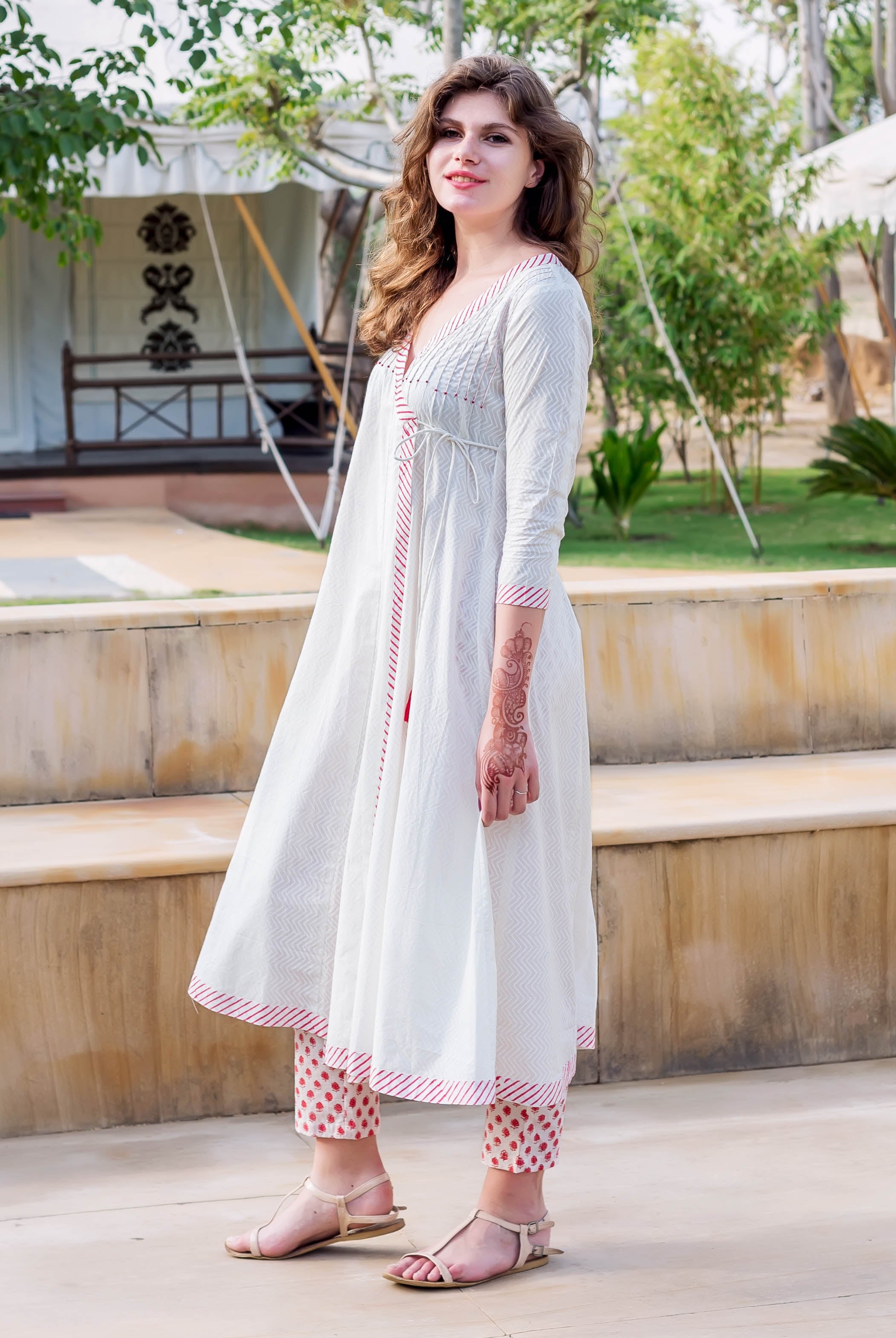 Model wearing a white Angrakha dress with red hand-block print and matching crop pants.