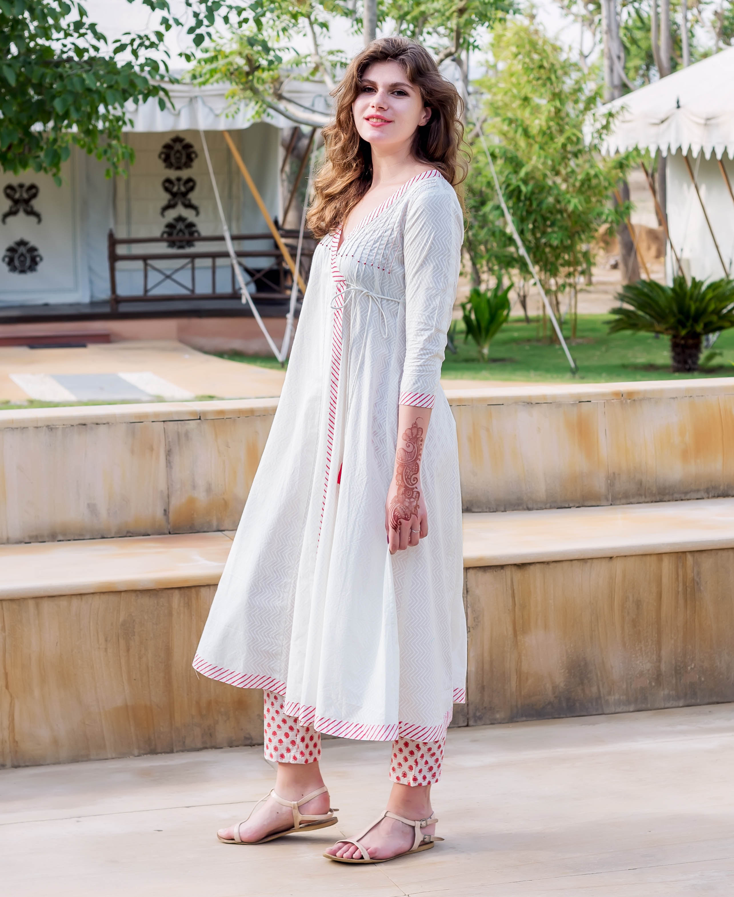 Model wearing a white Angrakha dress with red hand-block print and matching crop pants.