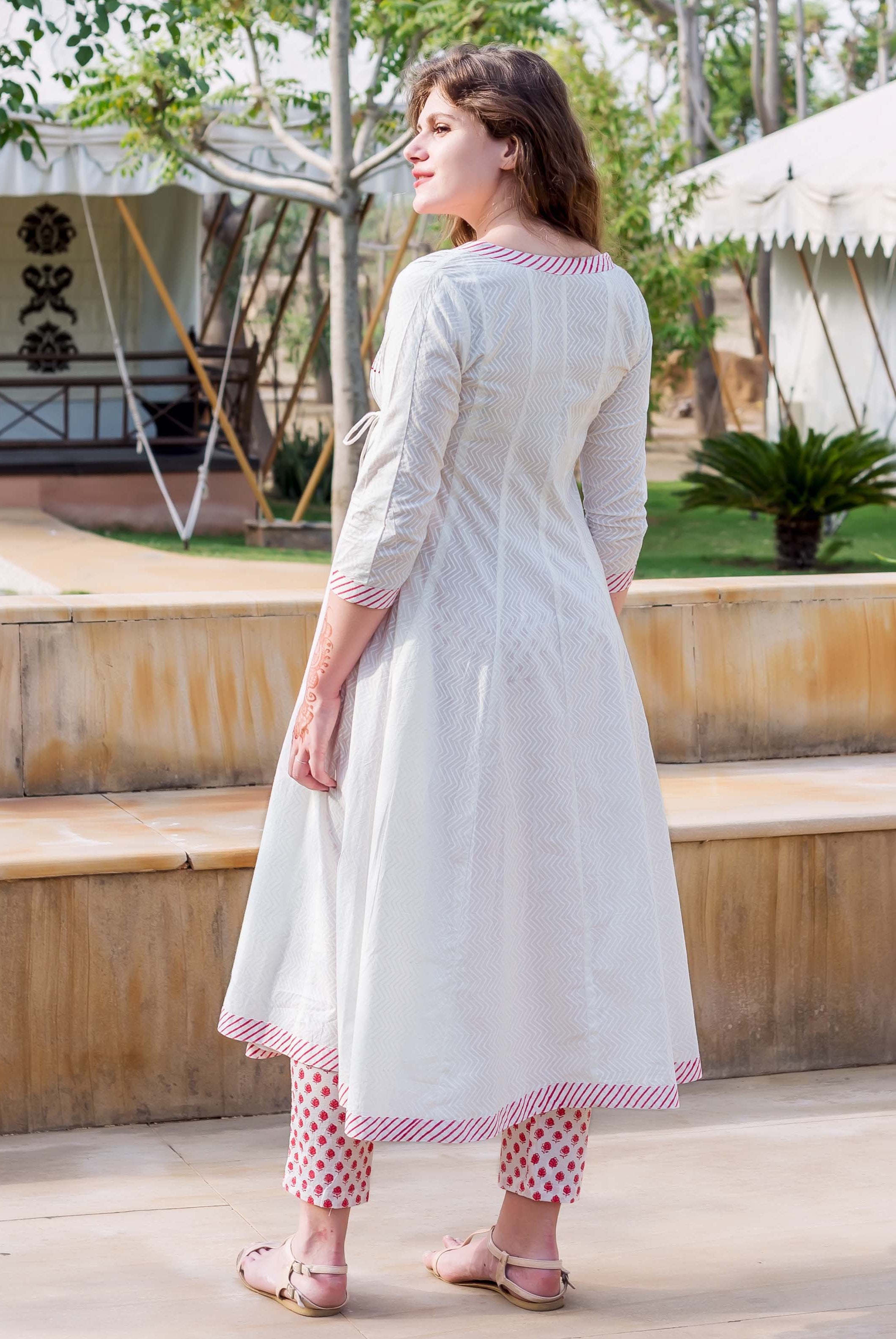 Rear view of model in white hand-block-printed Angrakha dress with red floral cropped pants.