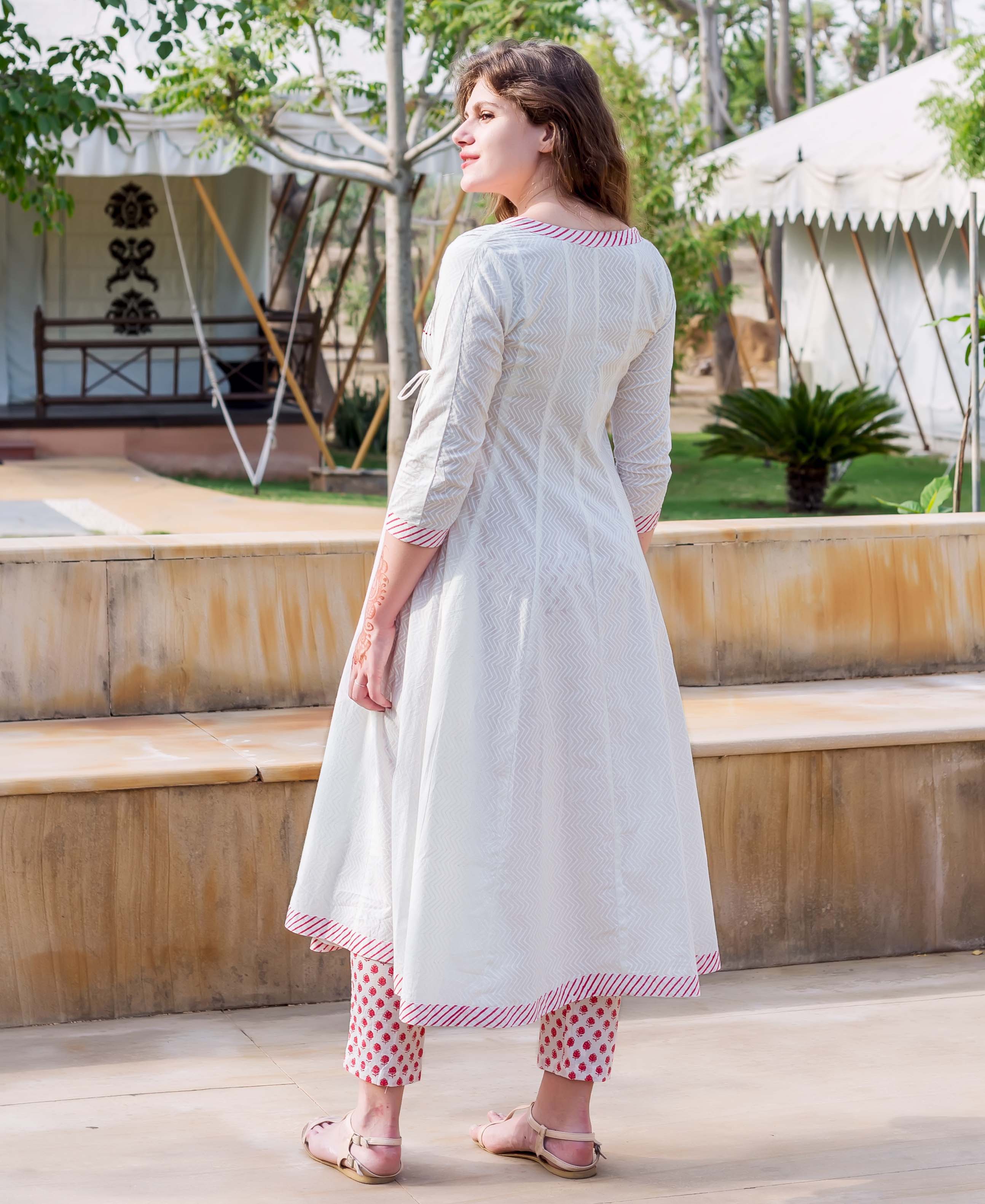 Rear view of model in white hand-block-printed Angrakha dress with red floral cropped pants.