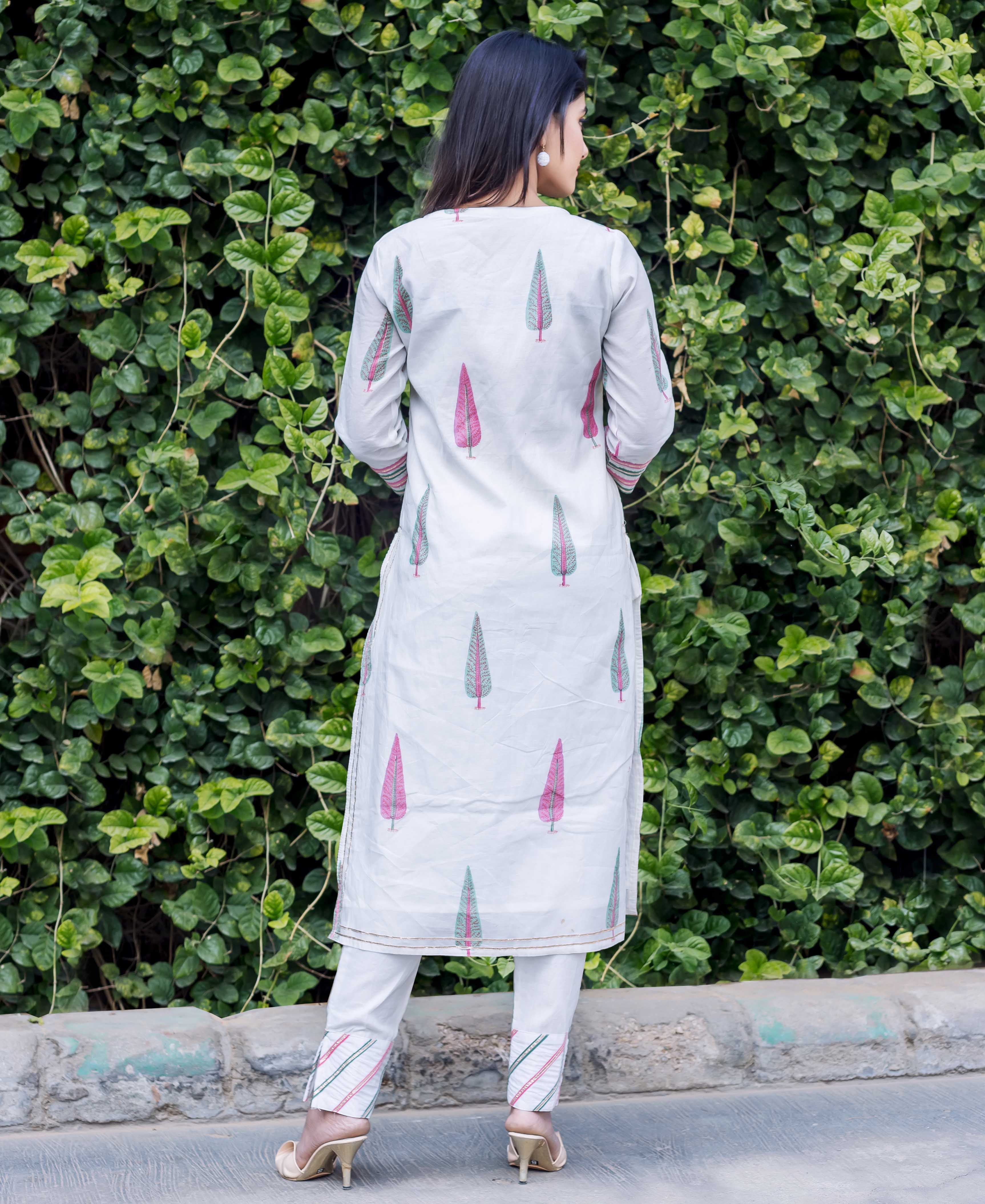 Back view of model wearing white chanderi kurta set with pink and green feather print.