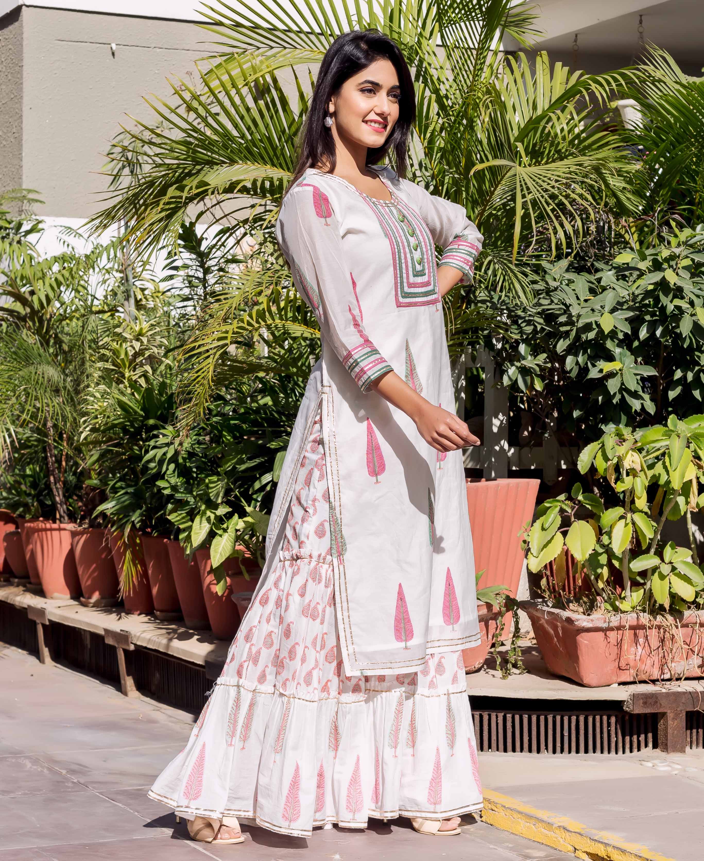 Full-length model in white chanderi block printed kurta and sharara with pink and green leaf motifs.