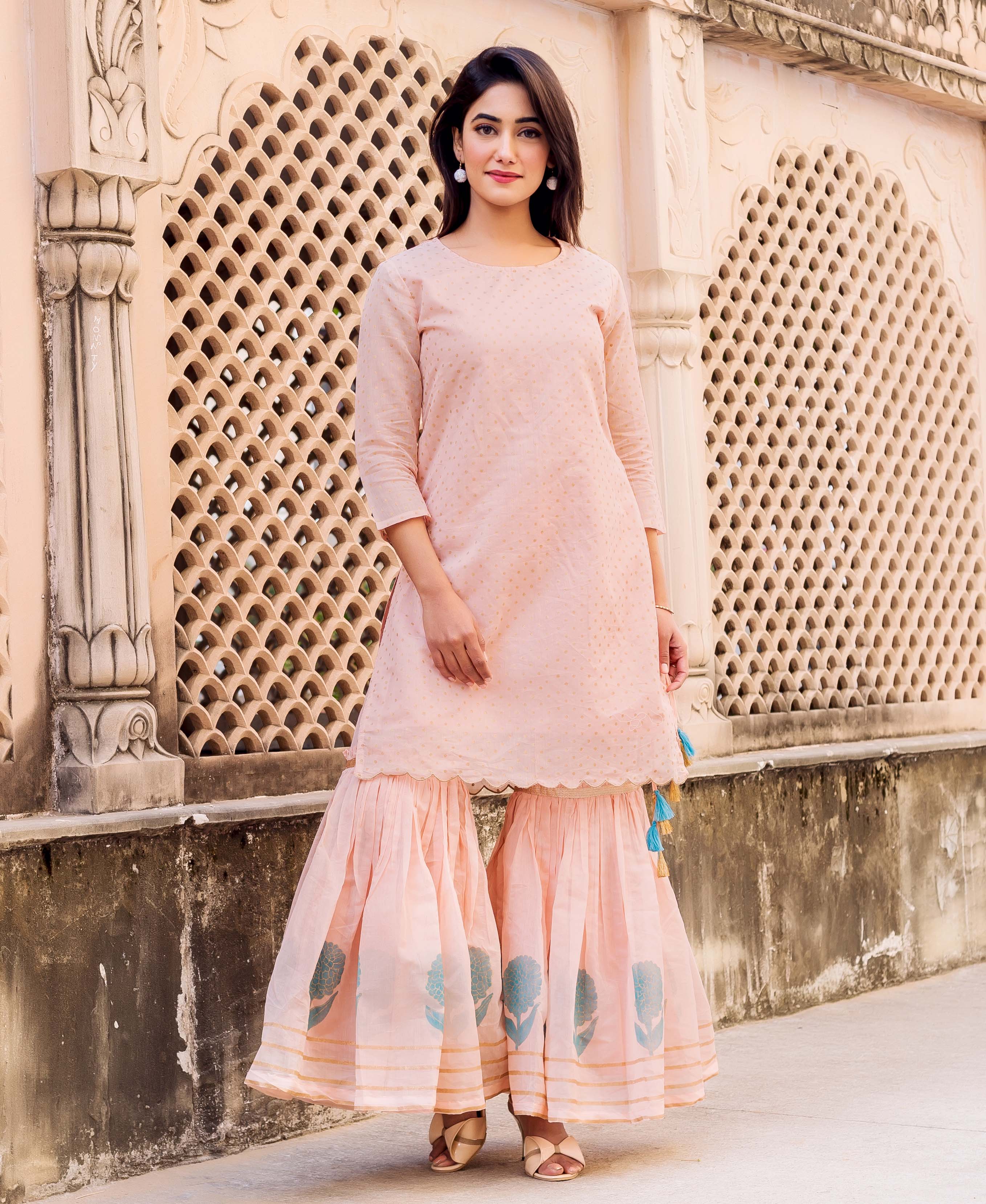 Peach polka printed kurta set with block-printed sharara on a full-length standing model.