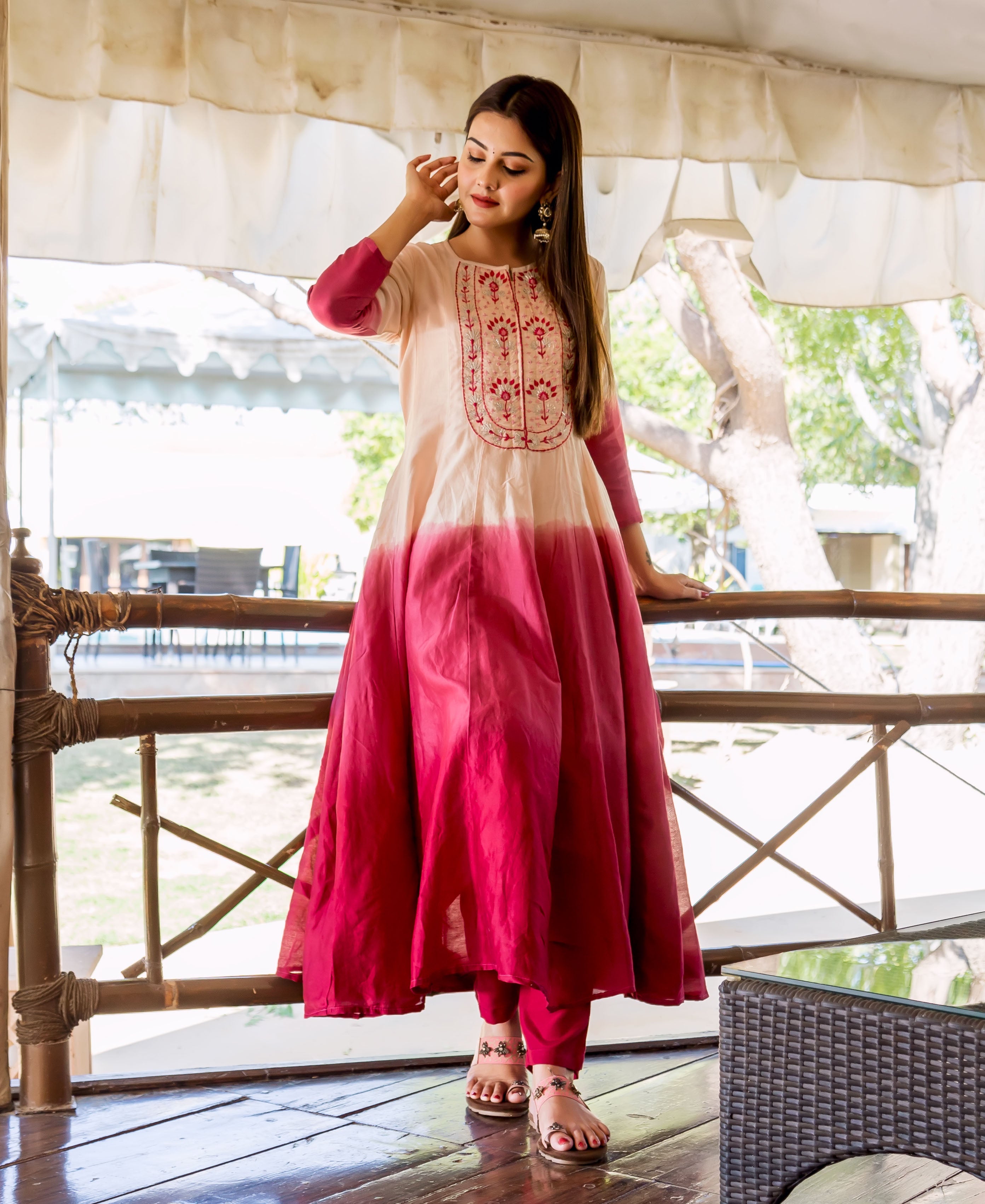 Full-length model wears a salmon-to-burgundy ombre Anarkali kurta with intricate red embroidery.