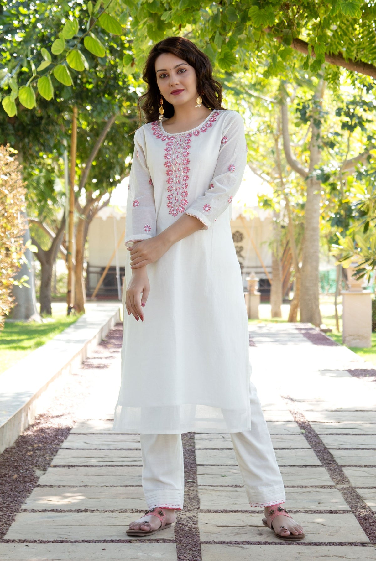 Full shot of model in white hand block printed kurta set with pink floral design.