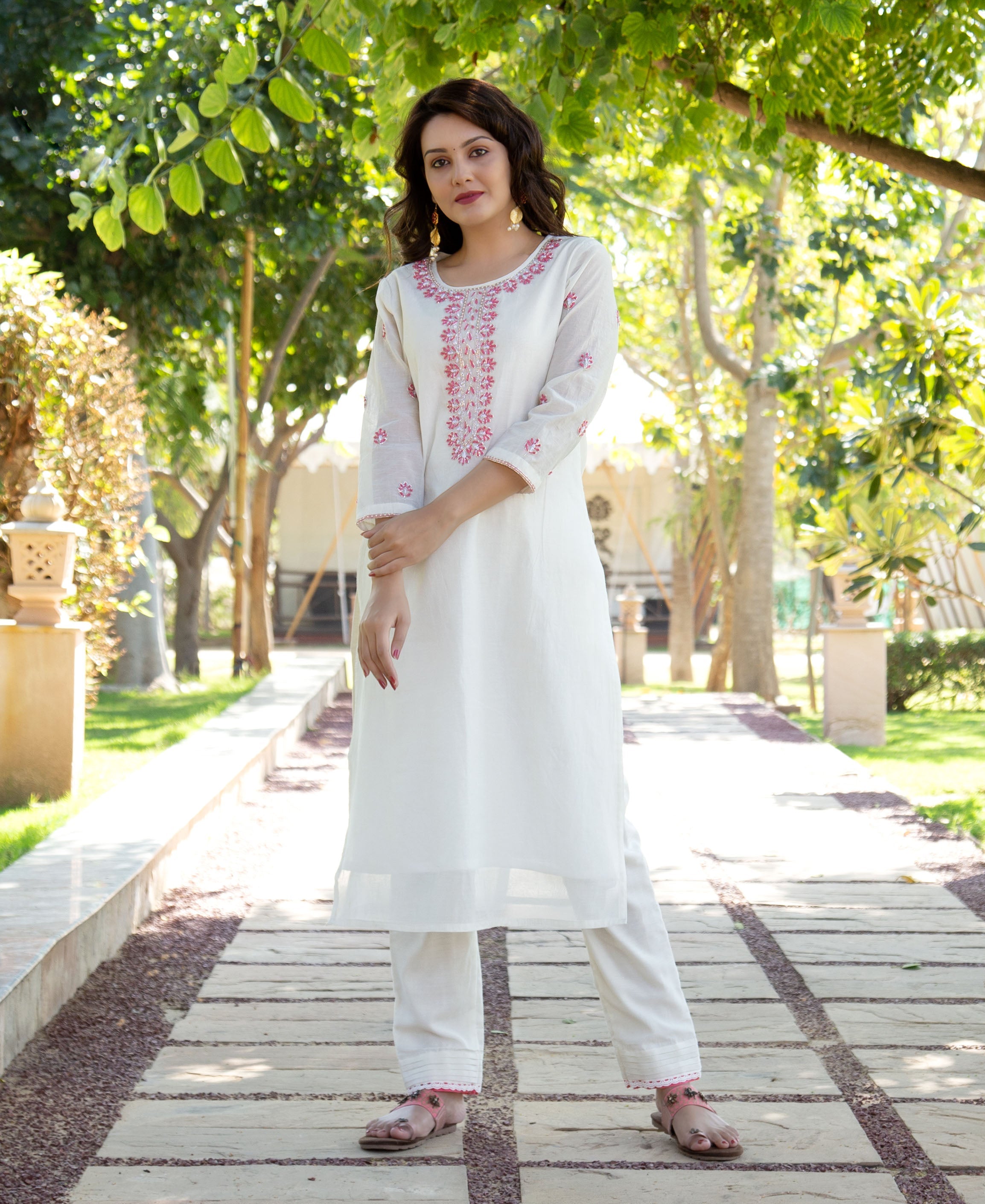 Full shot of model in white hand block printed kurta set with pink floral design.