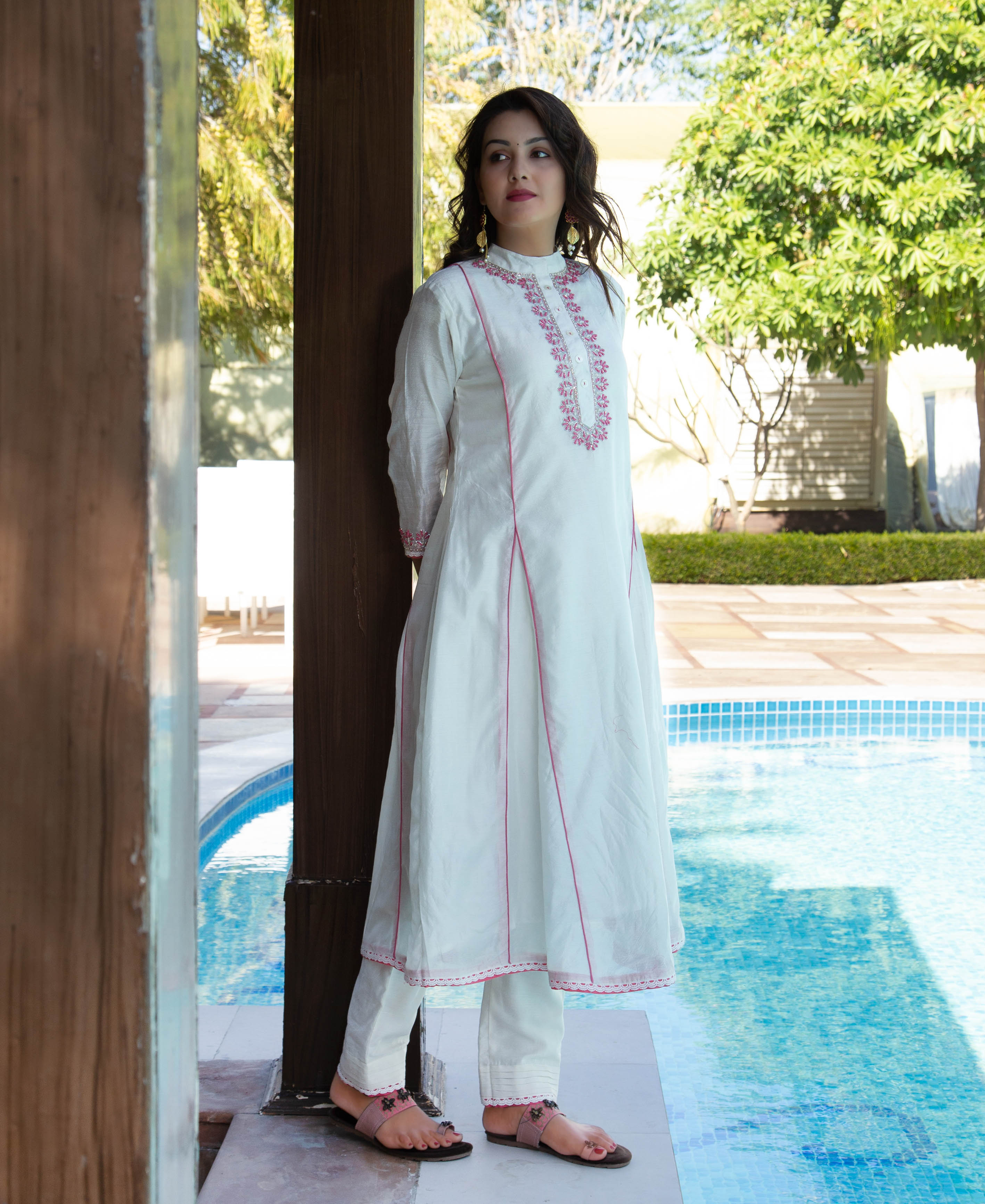 Full look: model wears white A-line kurta and pants with pink floral hand embroidery.