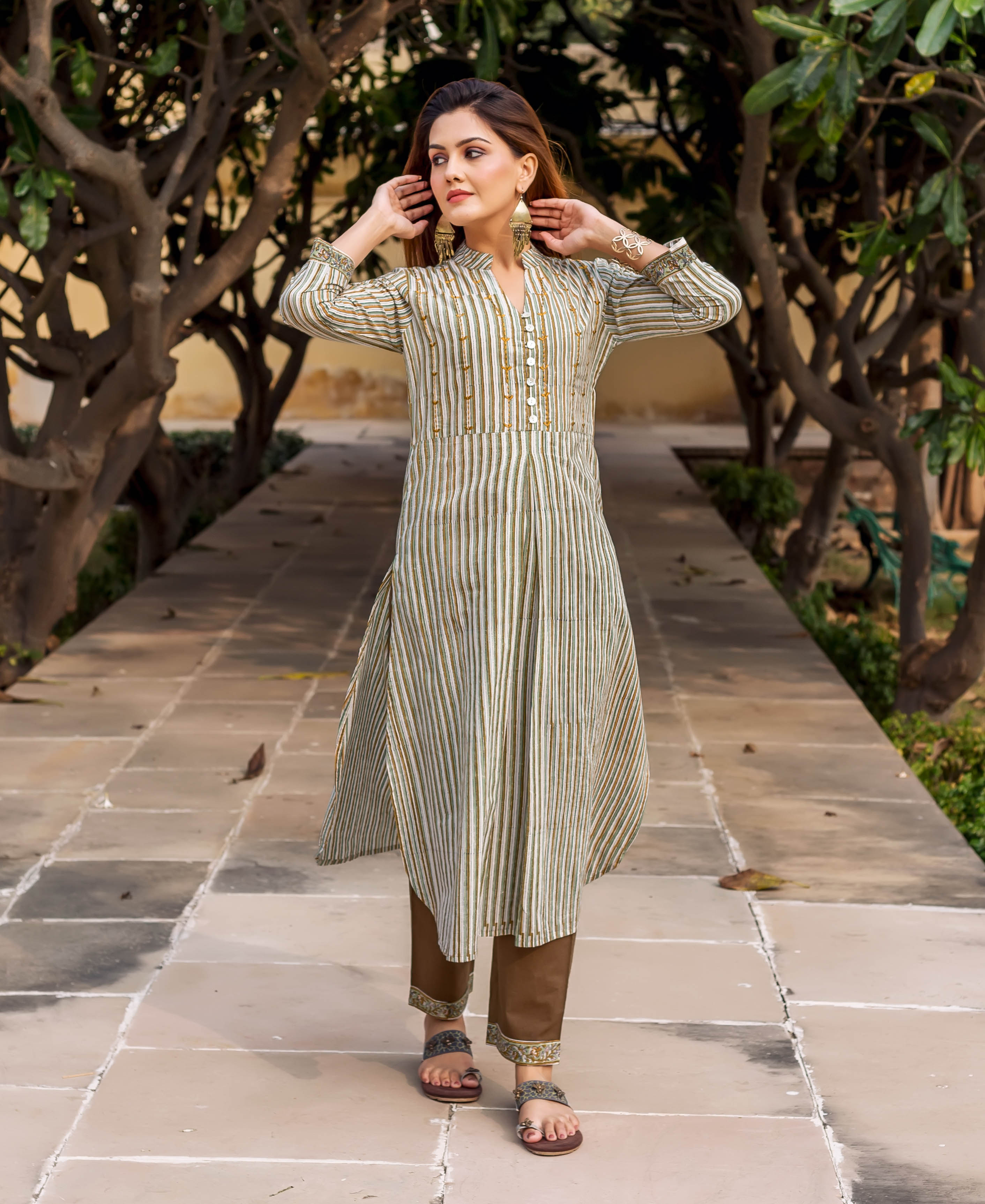 Model in full-length olive green striped printed and embroidered kurta set.