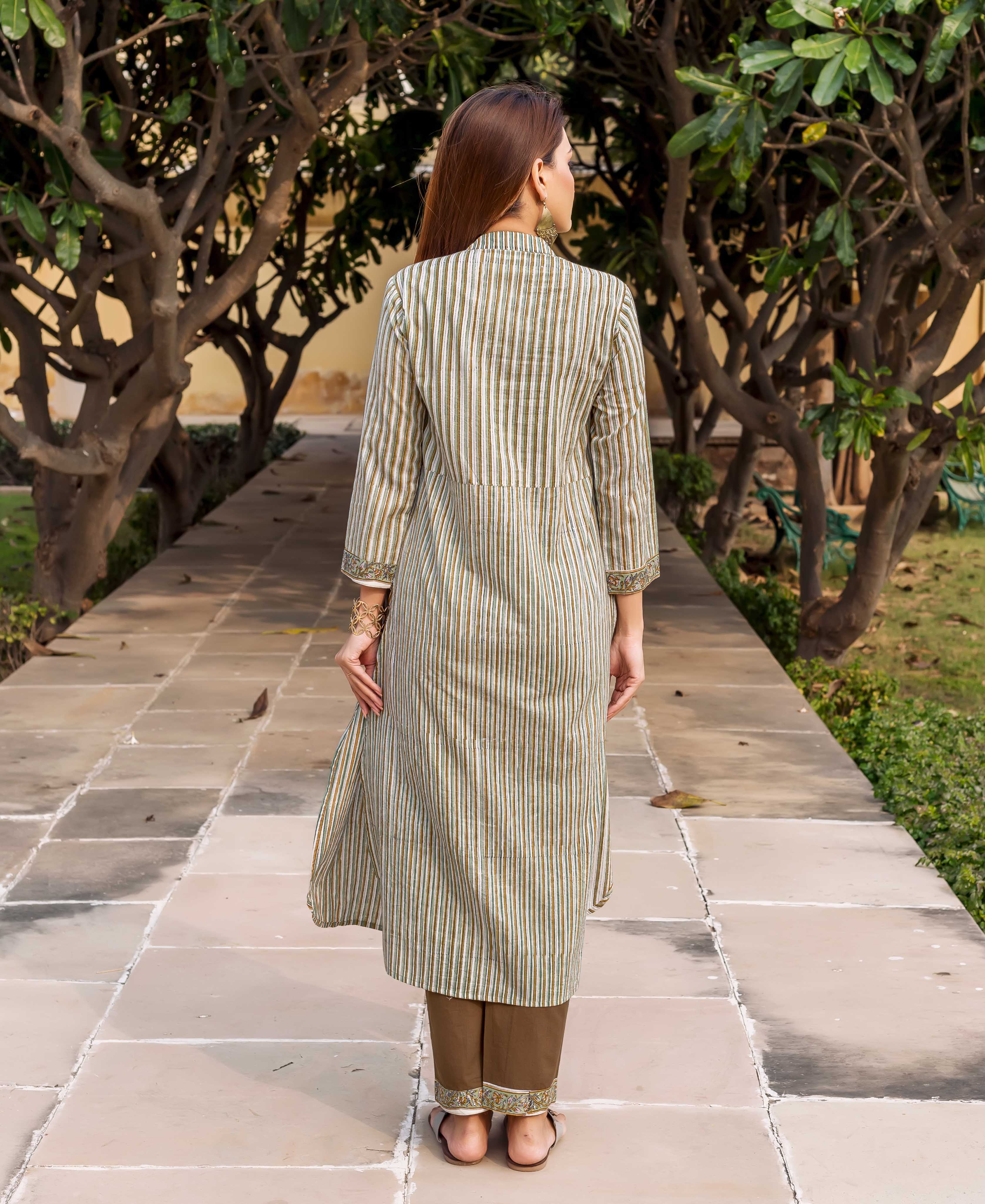 Back view of model in olive green striped kurta with embroidered sleeves and brown pants.